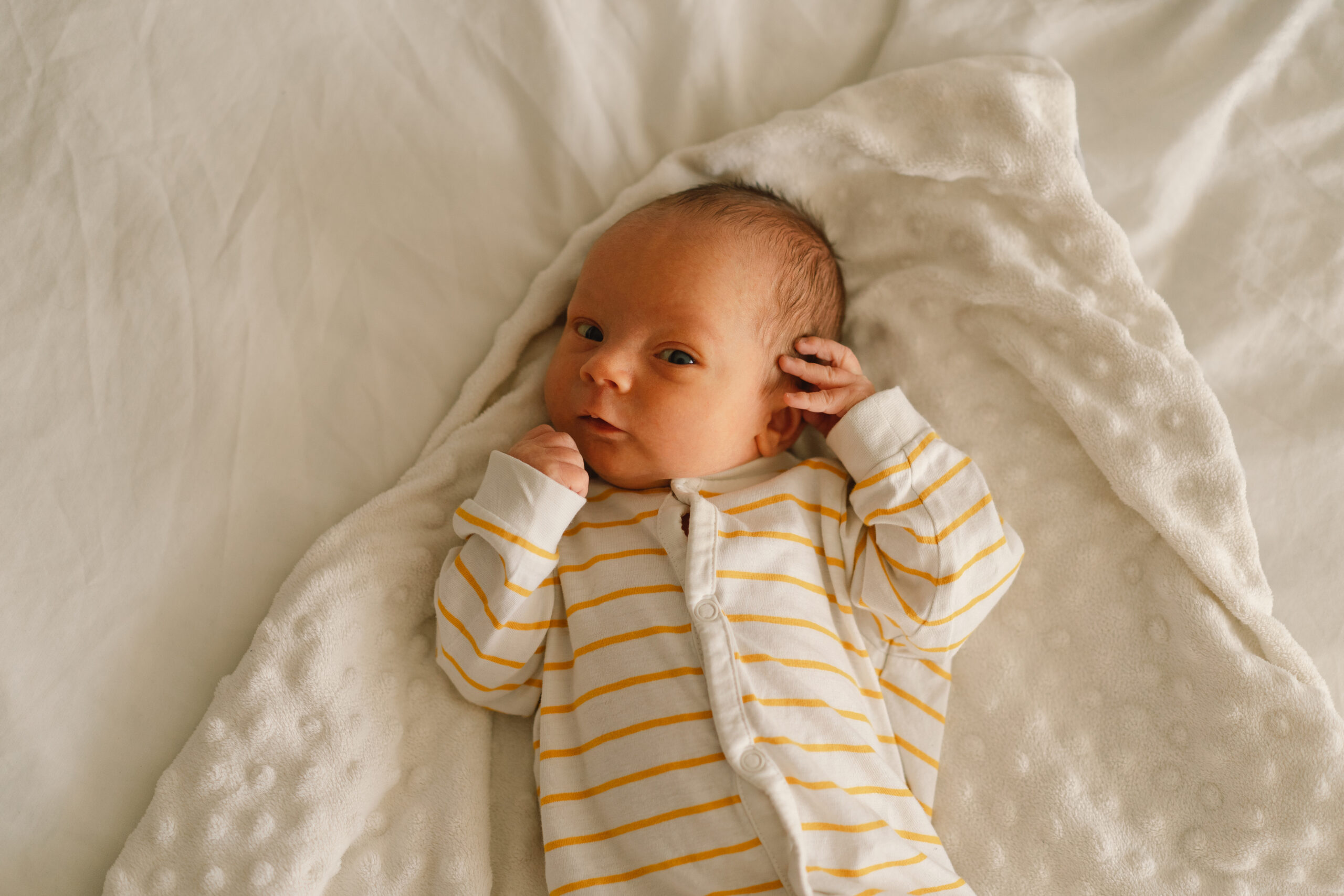 Cute emotional newborn little baby boy in crib. Baby goods packaging template.