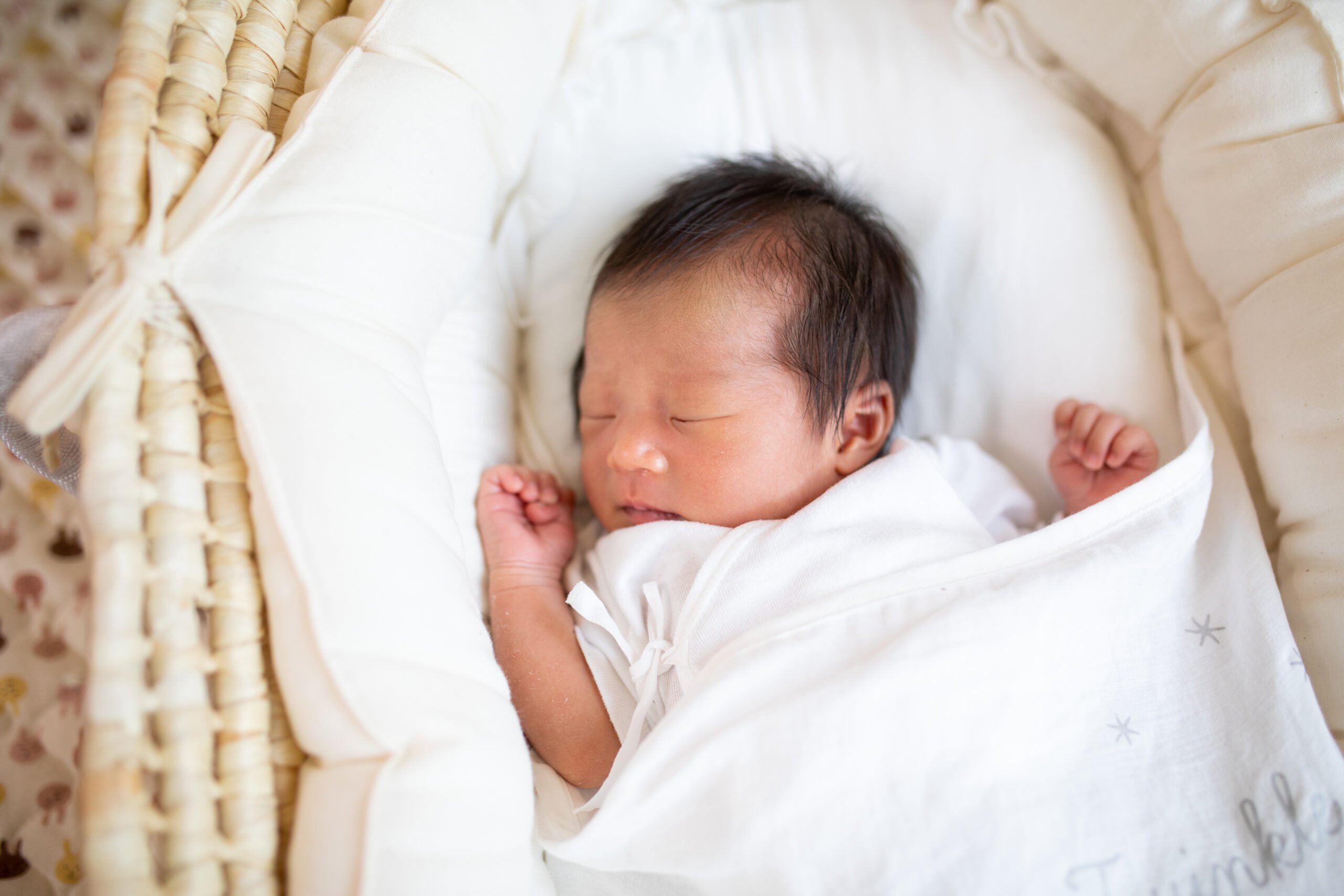 New born baby sleeping peacefully in a basket close up