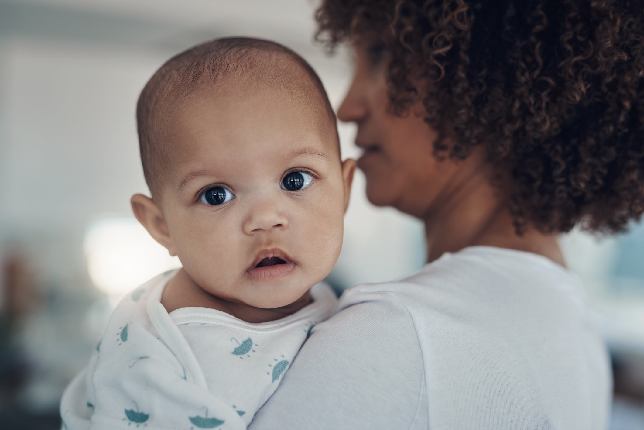 Shot of a young woman carrying her adorable baby girl at home