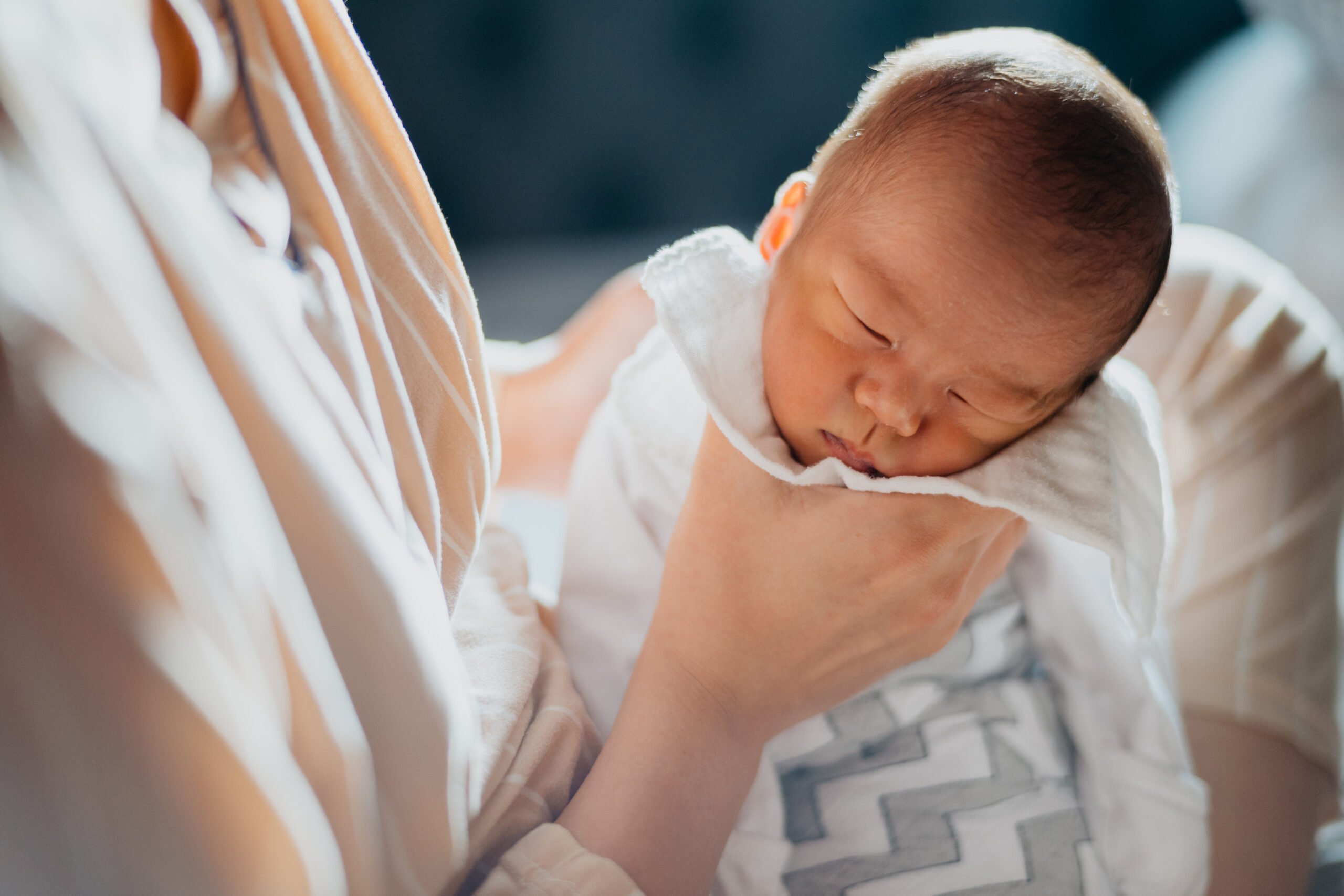 Asian mother burping baby after breastfeeding