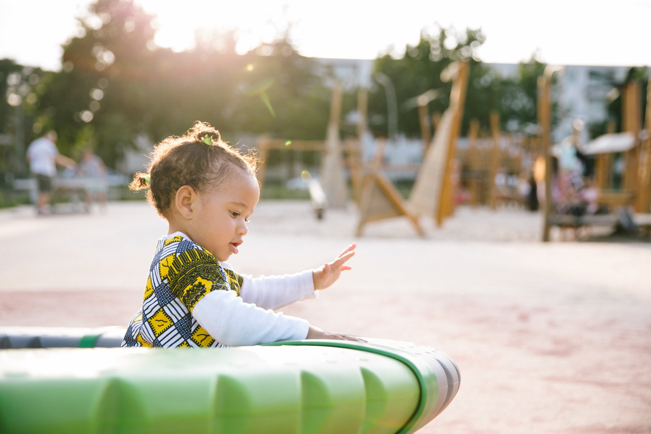 Carefree toddler playing on a playground in summer