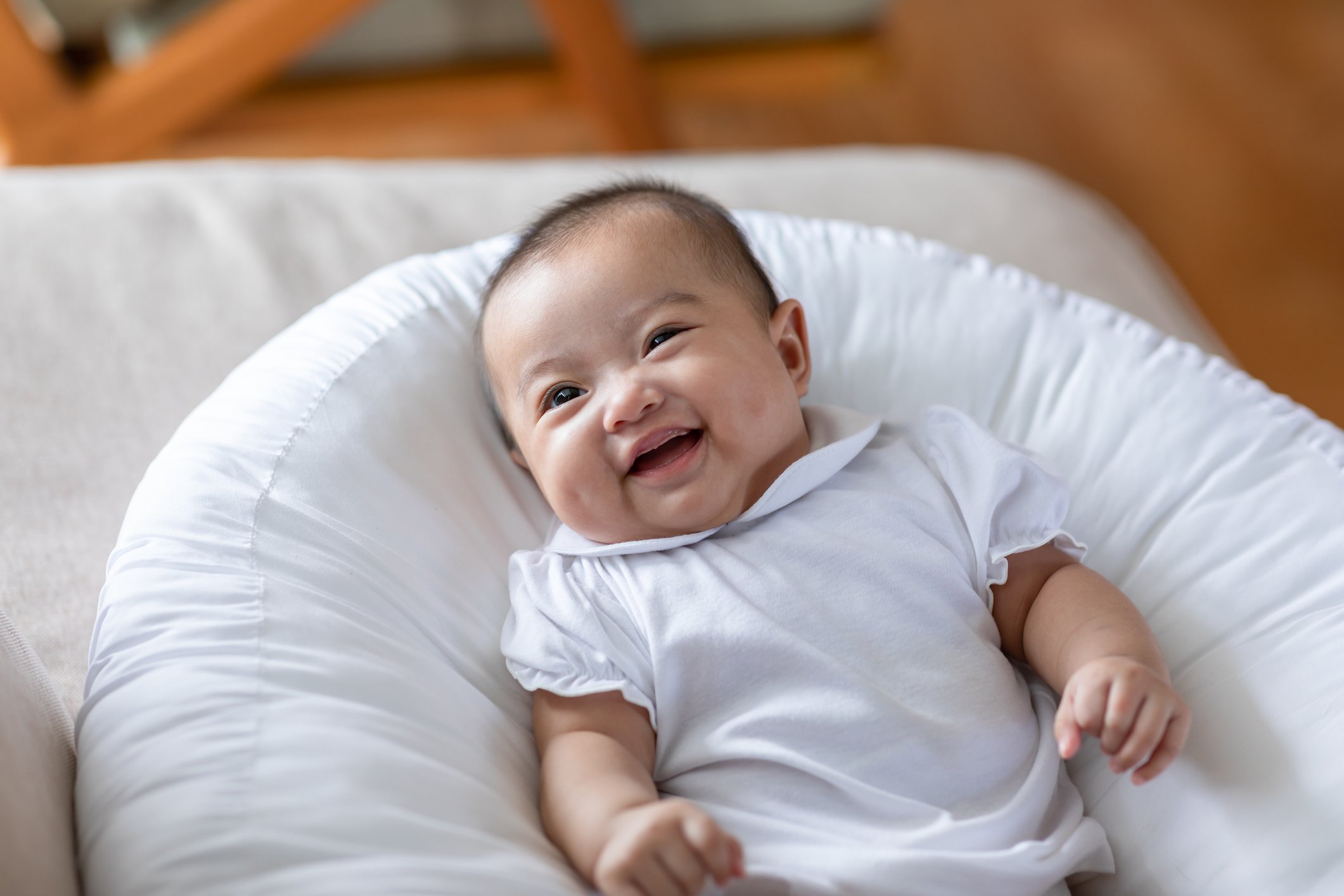 Adorable Asian baby girl lying on bed looking at camera.Cute little baby smiling and happiness relaxing in bed.Portrait of asian baby newborn in bedroom
