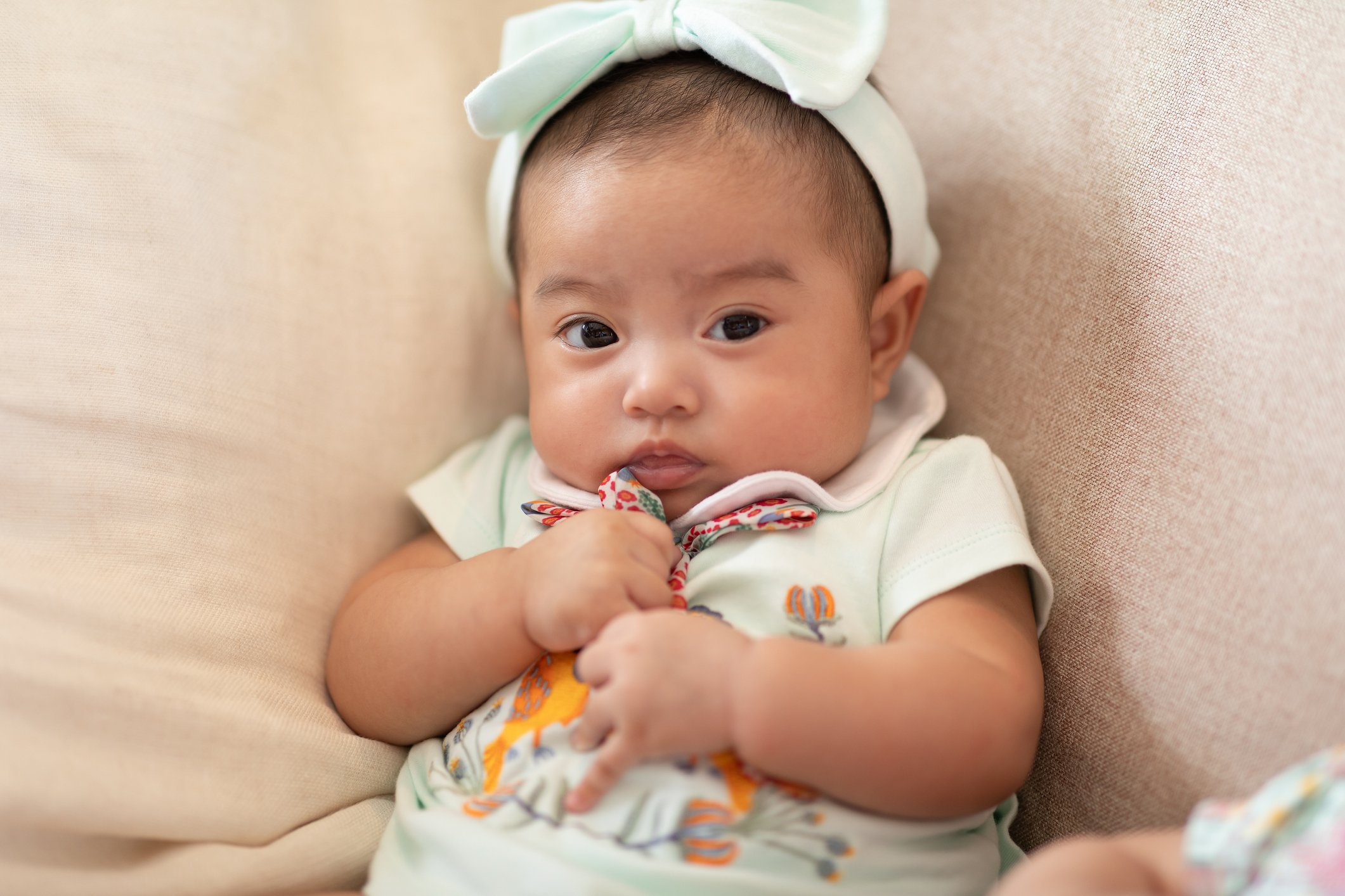 Adorable Asian baby girl lying on bed looking at camera.Cute little baby smiling and happiness relaxing in bed.Portrait of asian baby newborn in bedroom,Soft focus