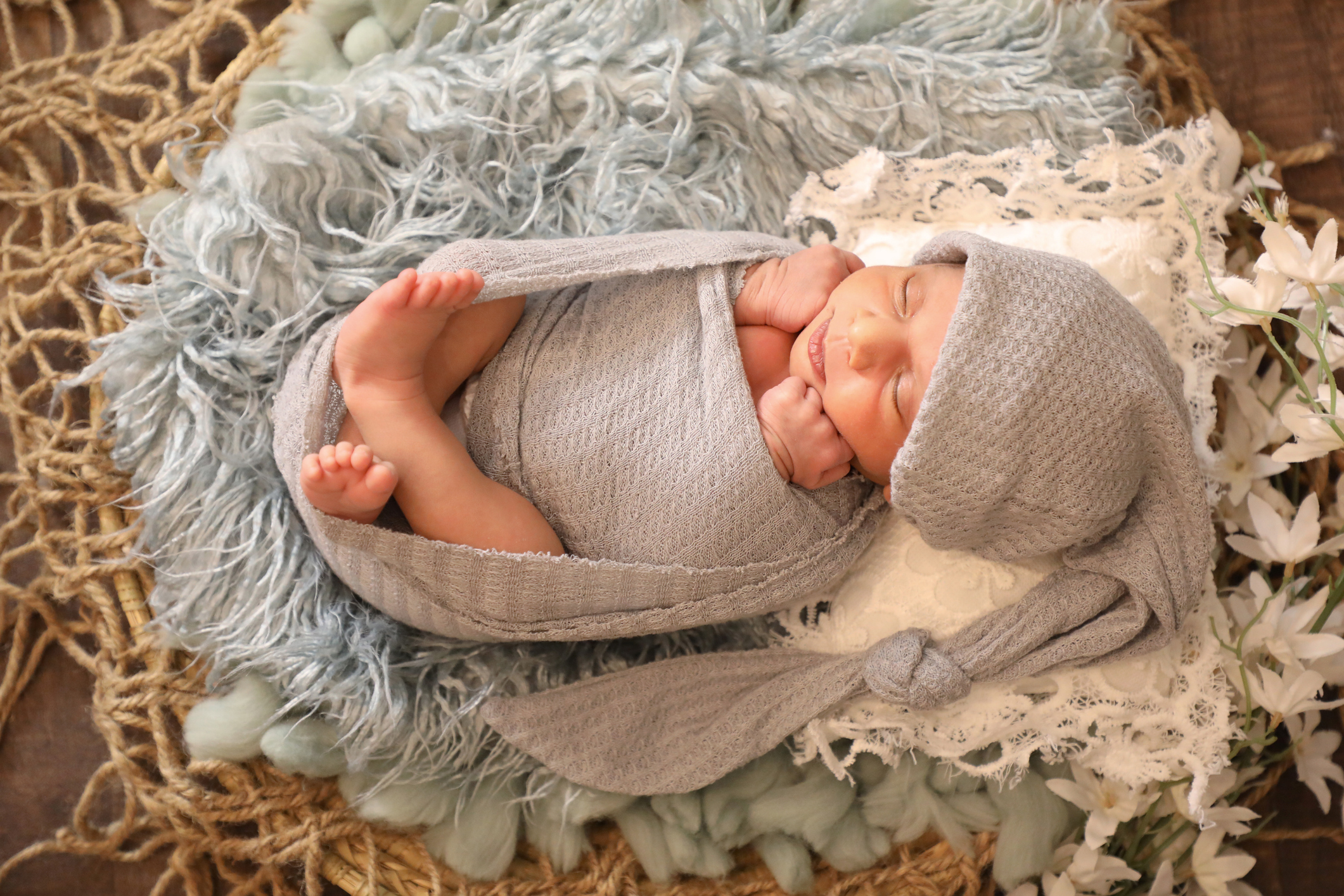 6 months old little sweet Arab Muslim girl laying and posing on comfy wool cute face top view portrait grey soft scarf