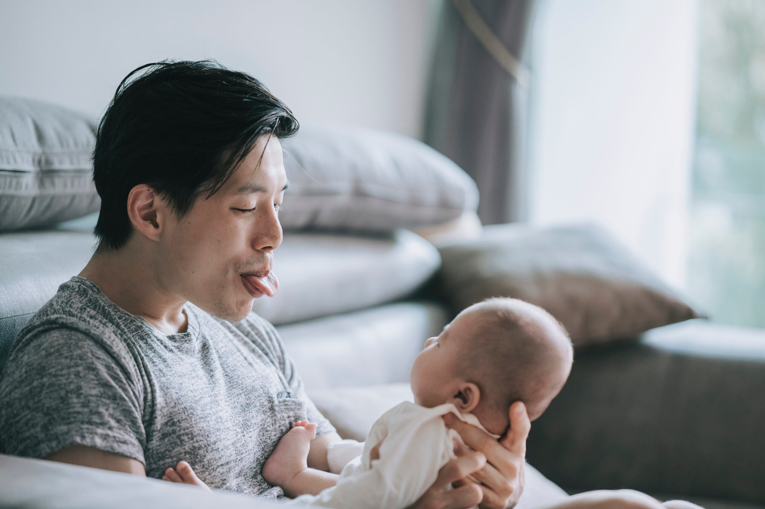 Asian Chinese young father bonding time playing with his baby boy son at living room during weekend