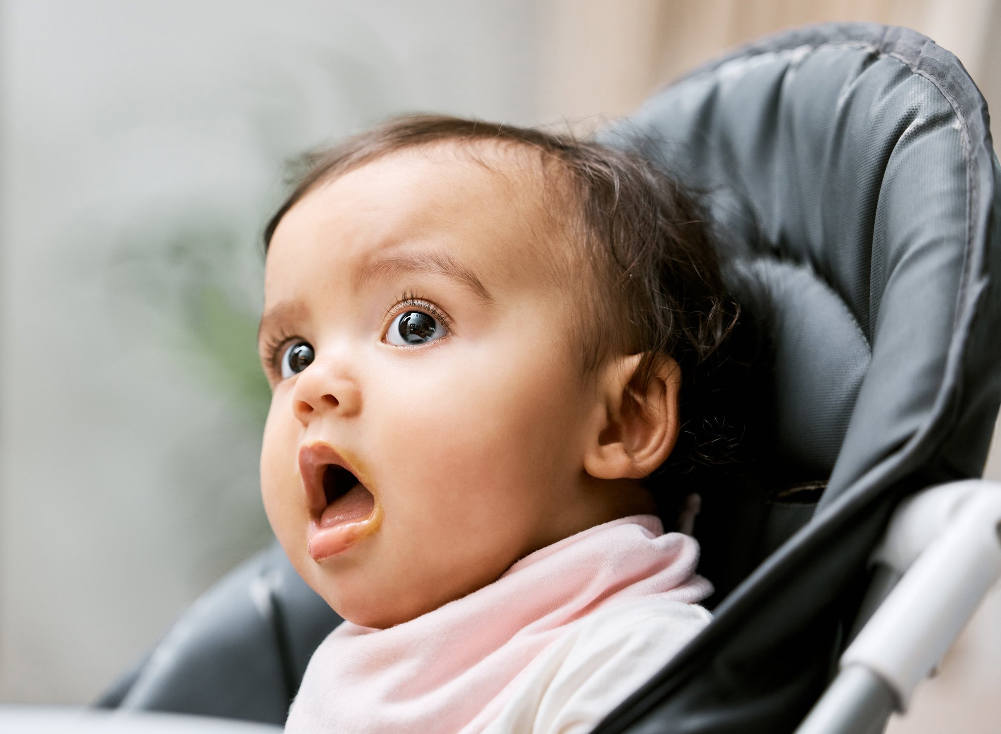 Shot of an adorable baby girl sitting in her feeding chair
