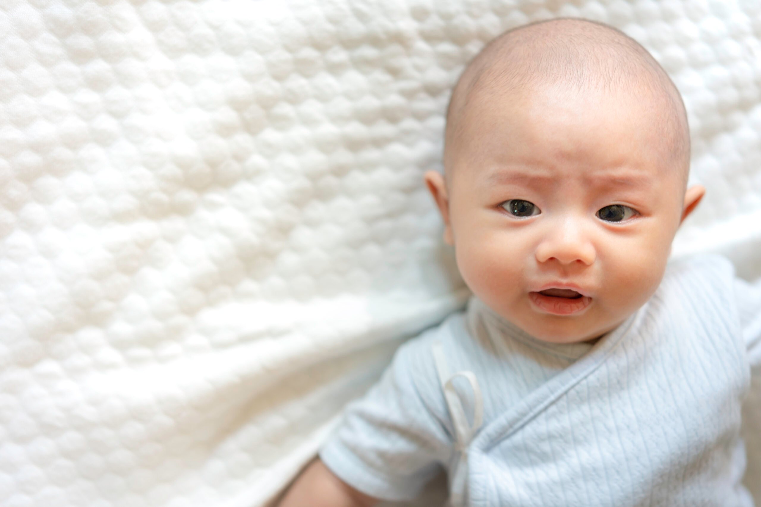 Adorable, Asian newborn. Baby boy looking camera. Little innocent new infant child in first day of life. Mother day concept.