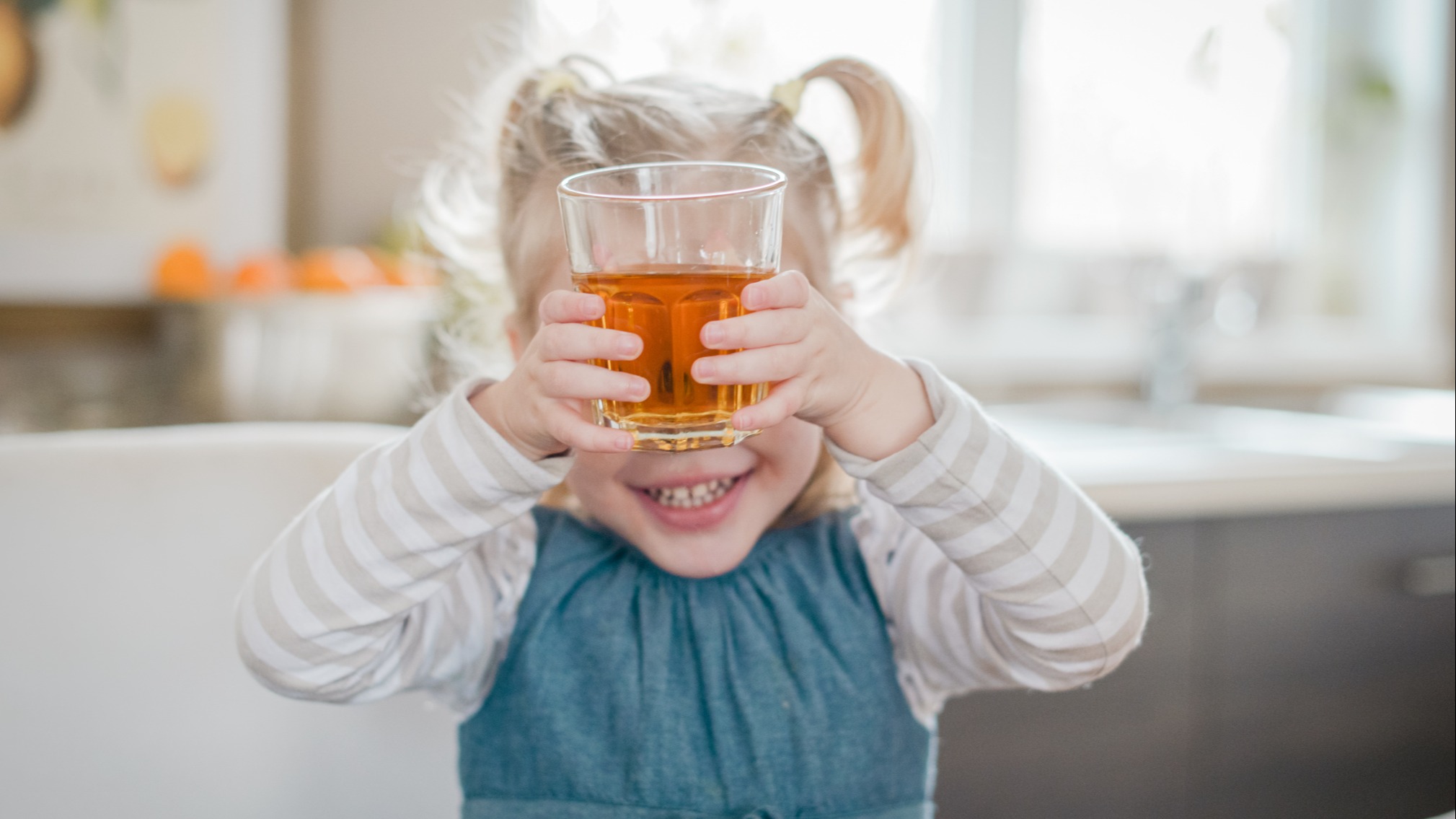 Baby holding a drink up