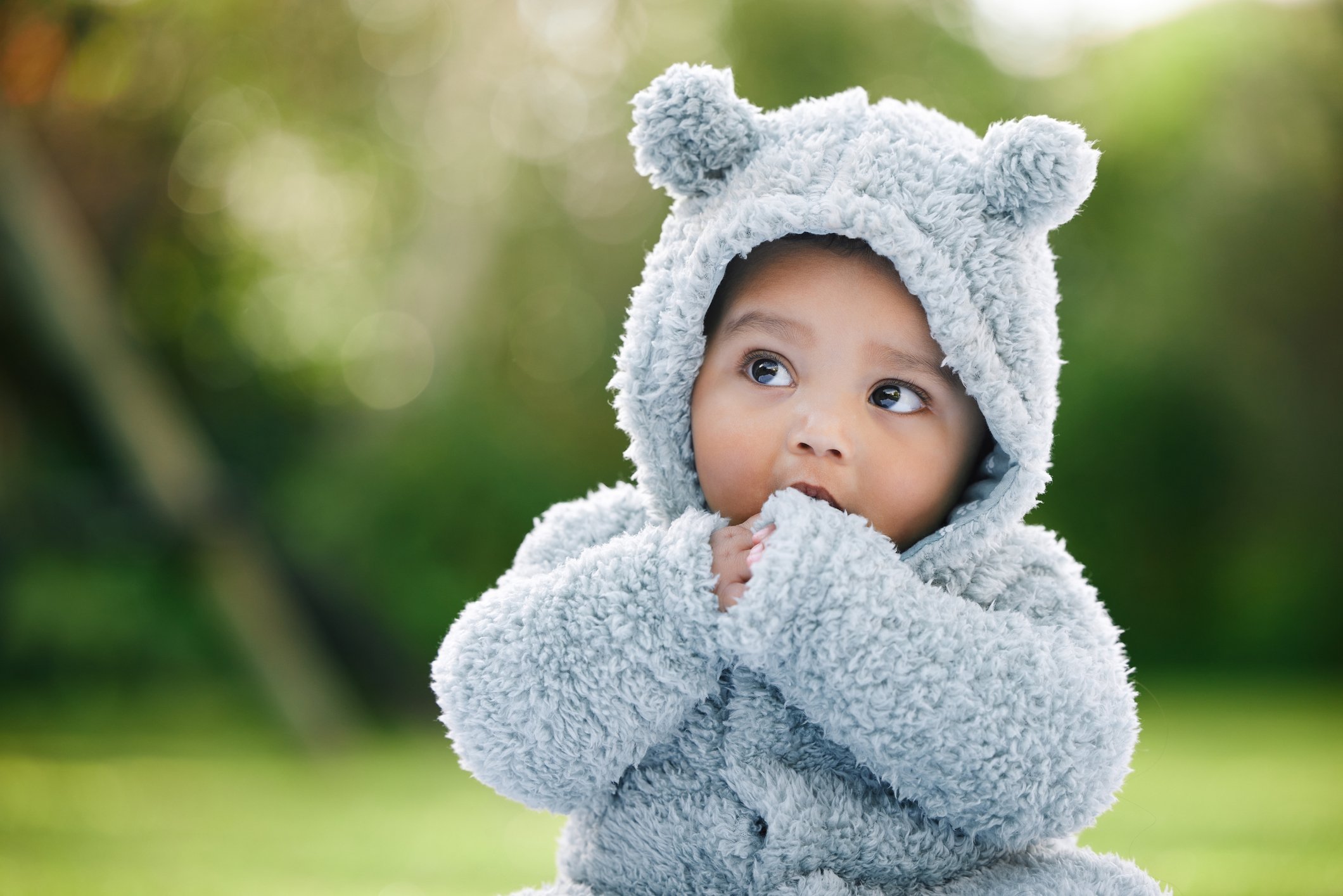 Shot of an adorable baby boy wearing a furry jacket with bear ears outdoors