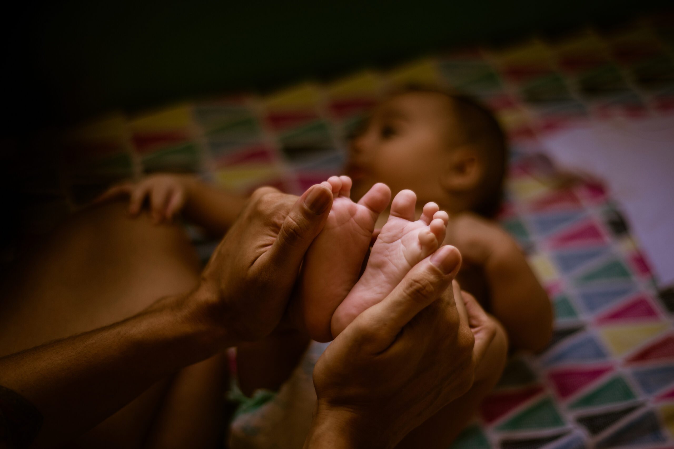 Mother holding baby's feet. Baby massage.