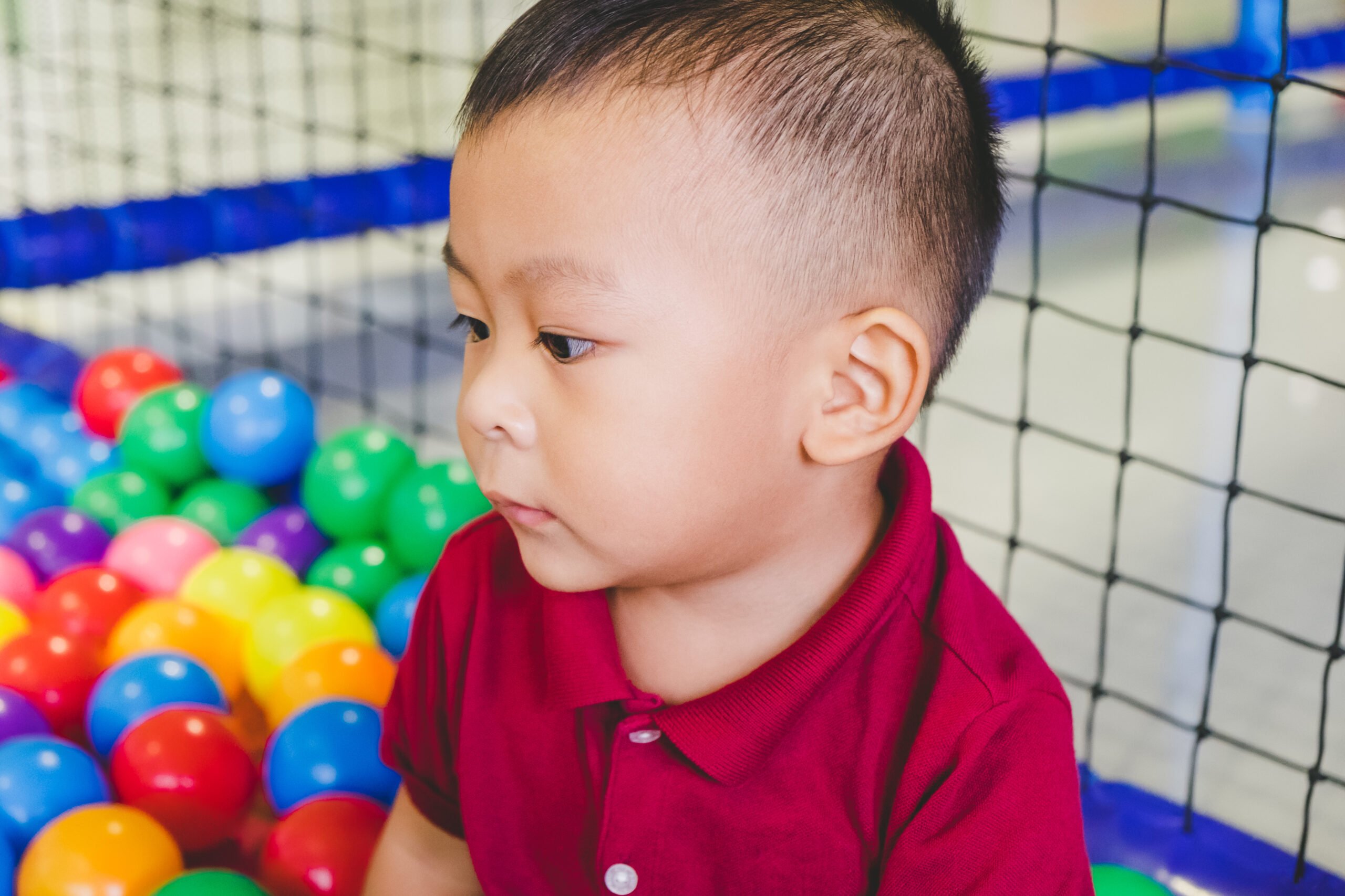 Little Asian baby boy in playground center