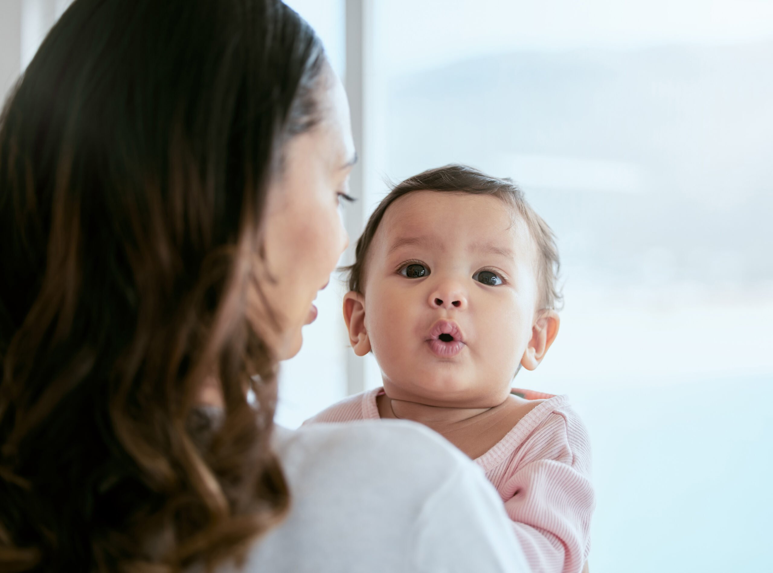 Shot of a mother holding her baby daughter at home
