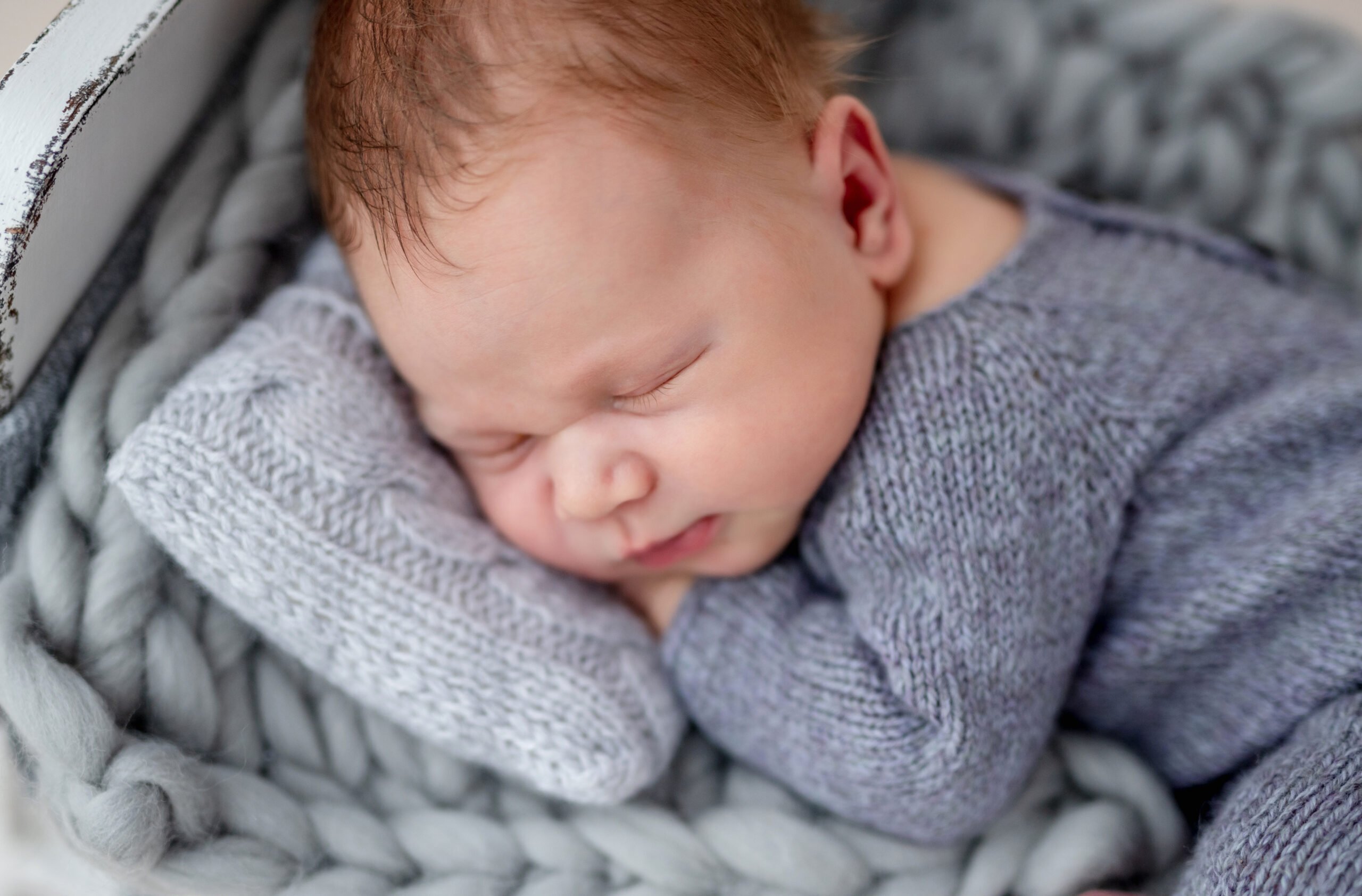 Cute newborn on tiny bed