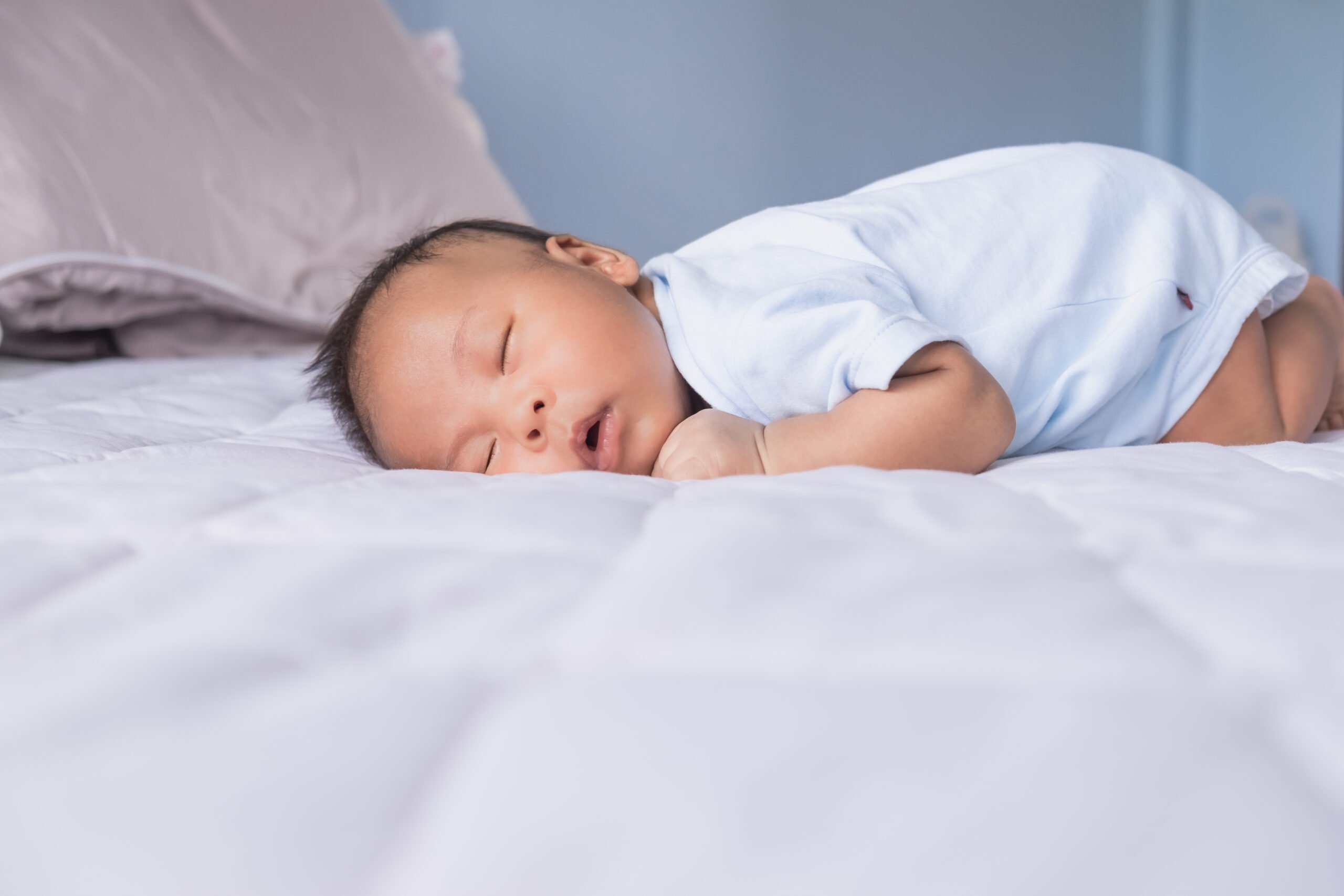 Relaxing cute Asian newborn baby boy lying fast sleeping