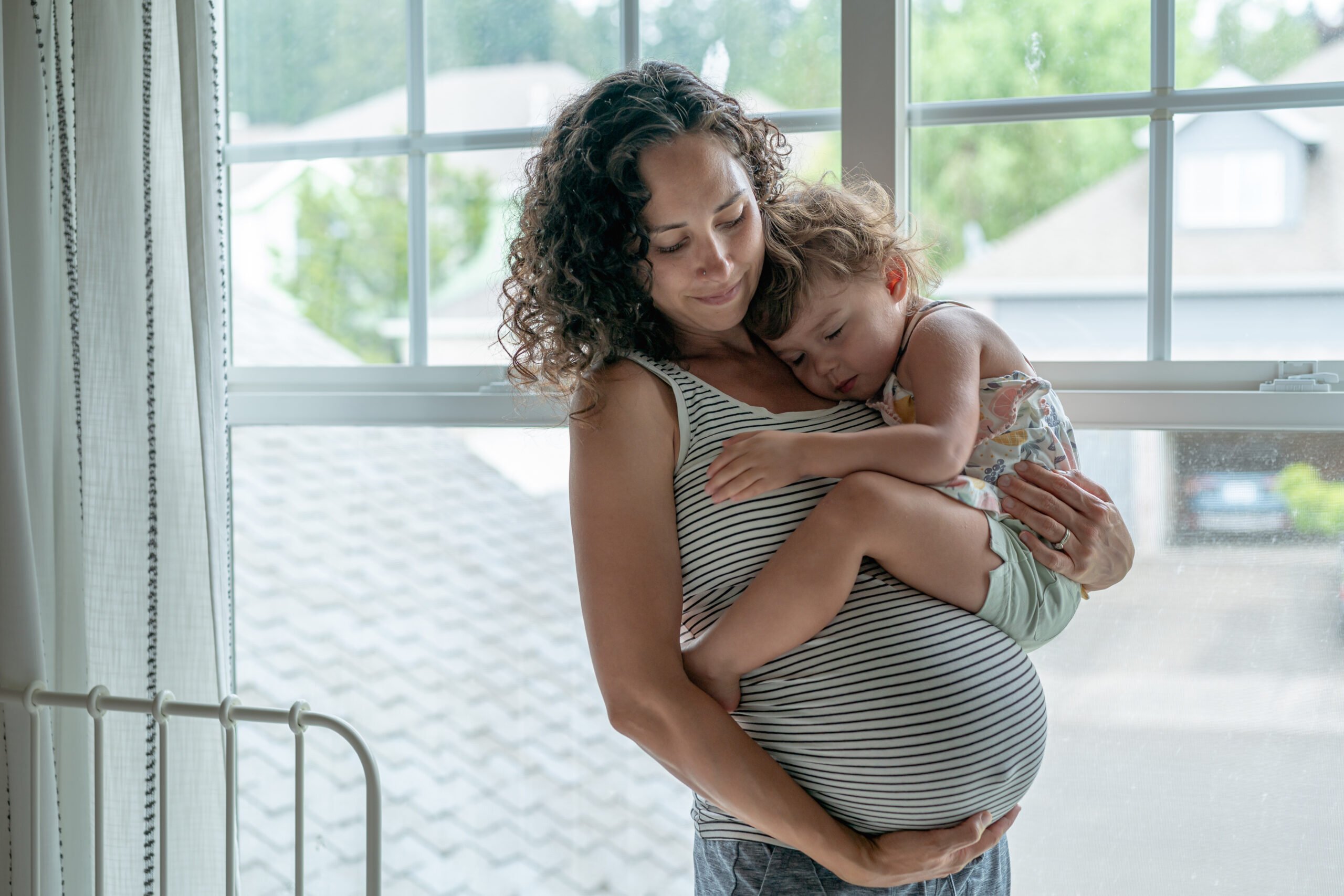 pregnant woman holding toddler