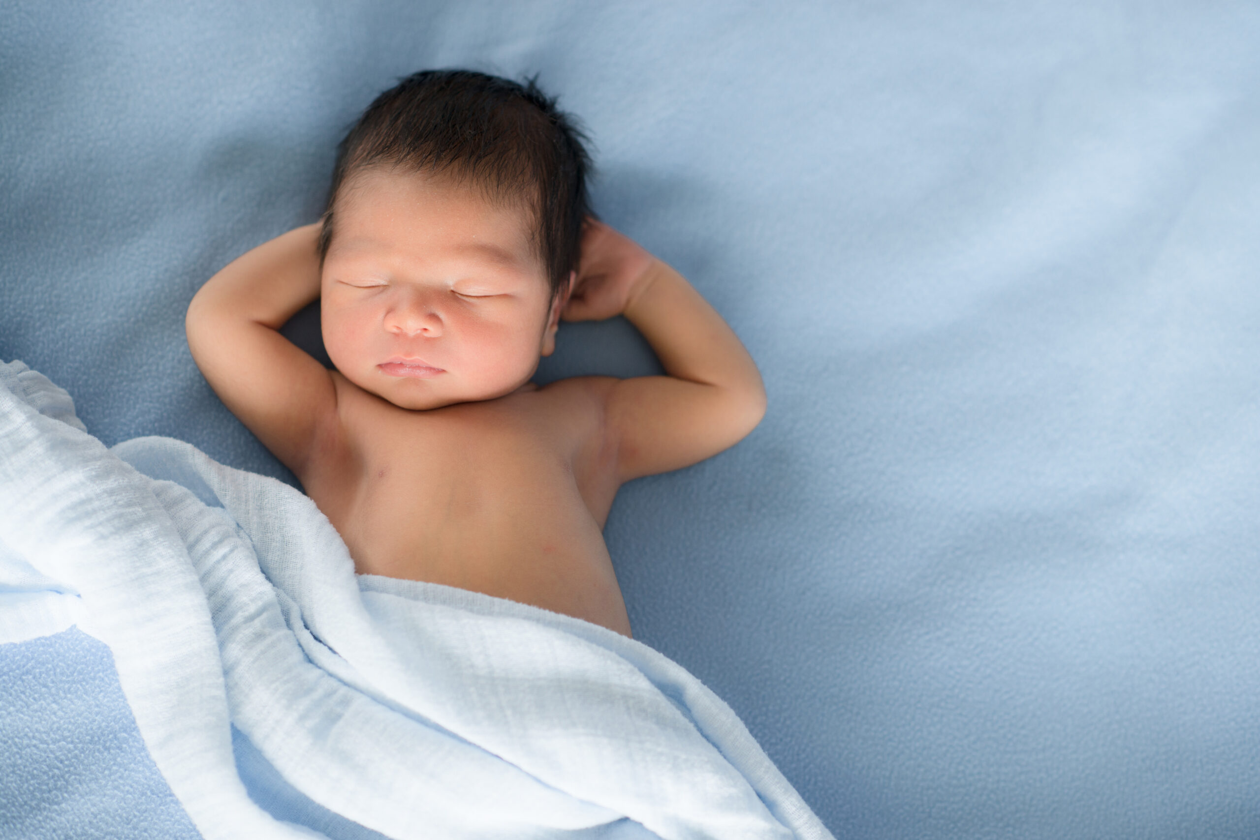 Newborn baby sleeps on blue blankets
