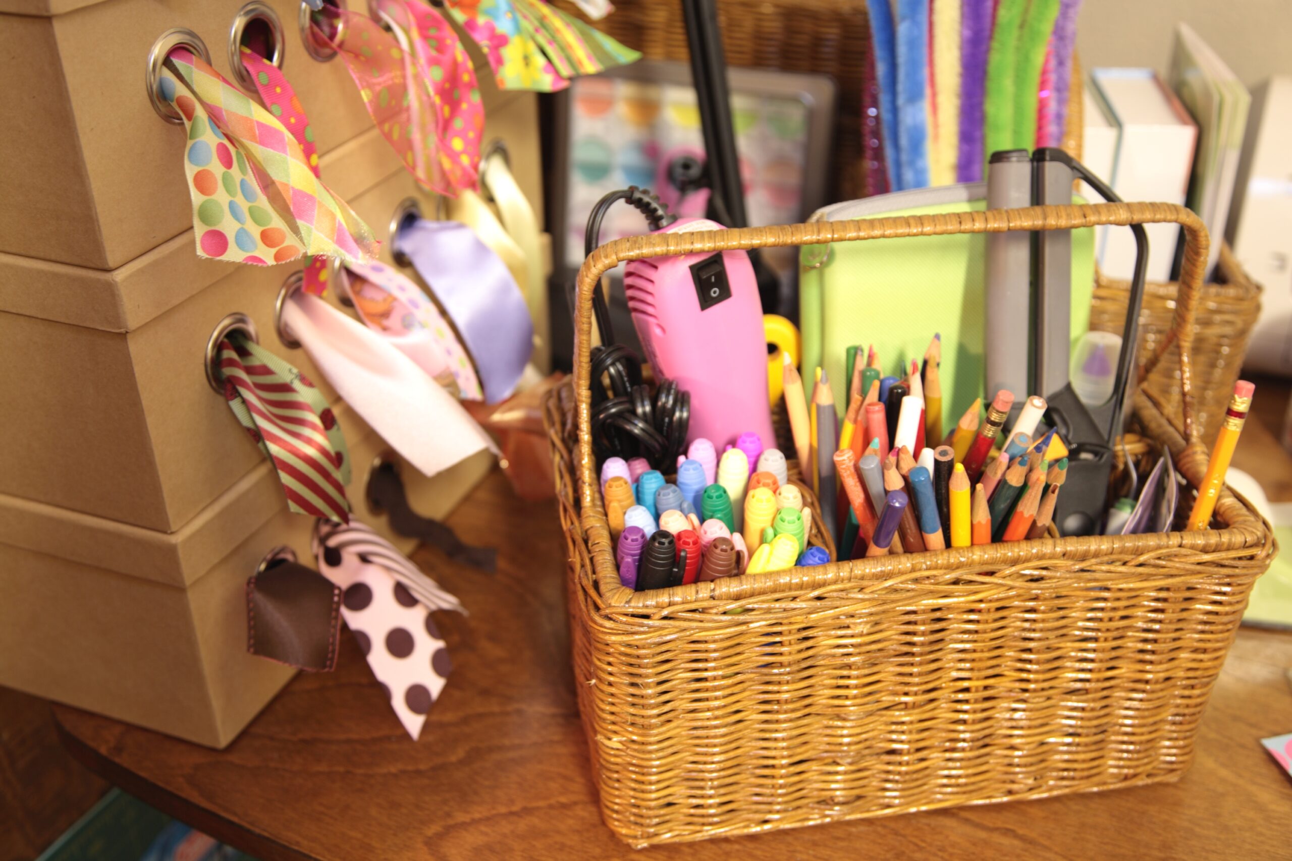 craft supplies with ribbon, markers, colored pencils in basket