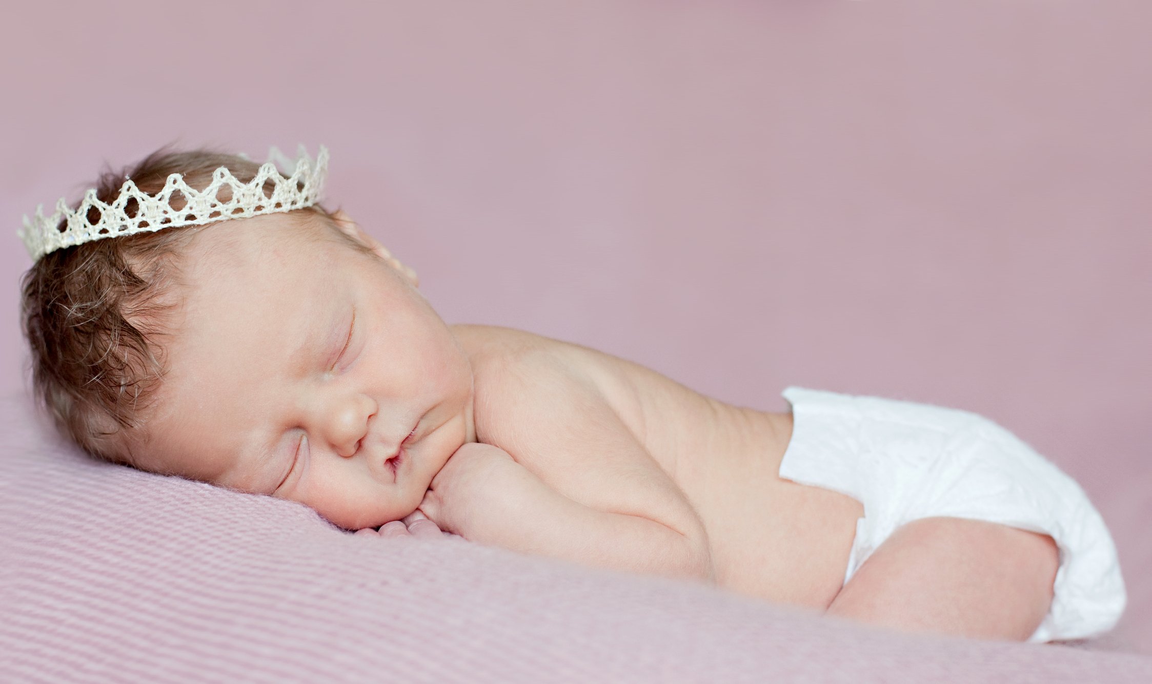 Newborn Princess. Baby girl sleeping with lace crown.