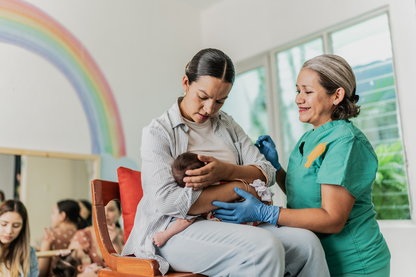 Mature woman learning to breastfeed her daughter in support group