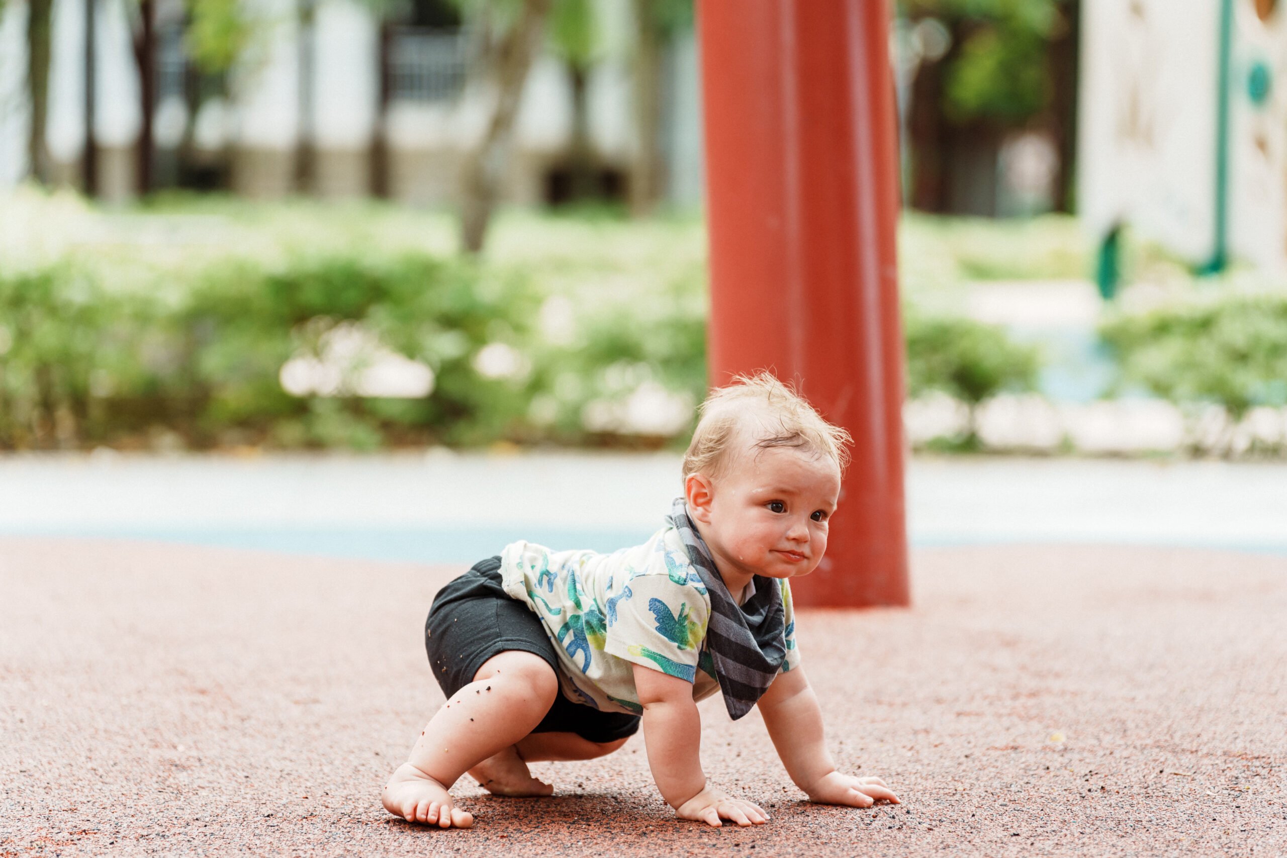 Baby boy crawling outside at the park