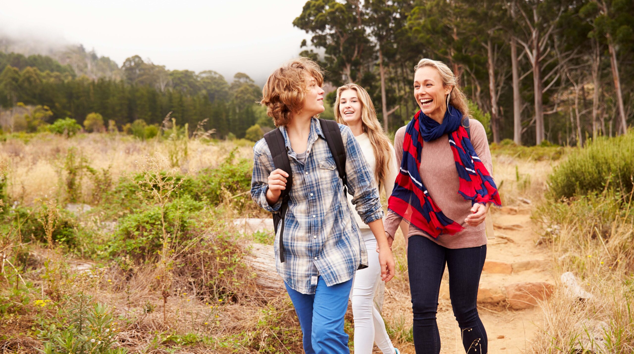 Mother and two kids walking on a forest trail