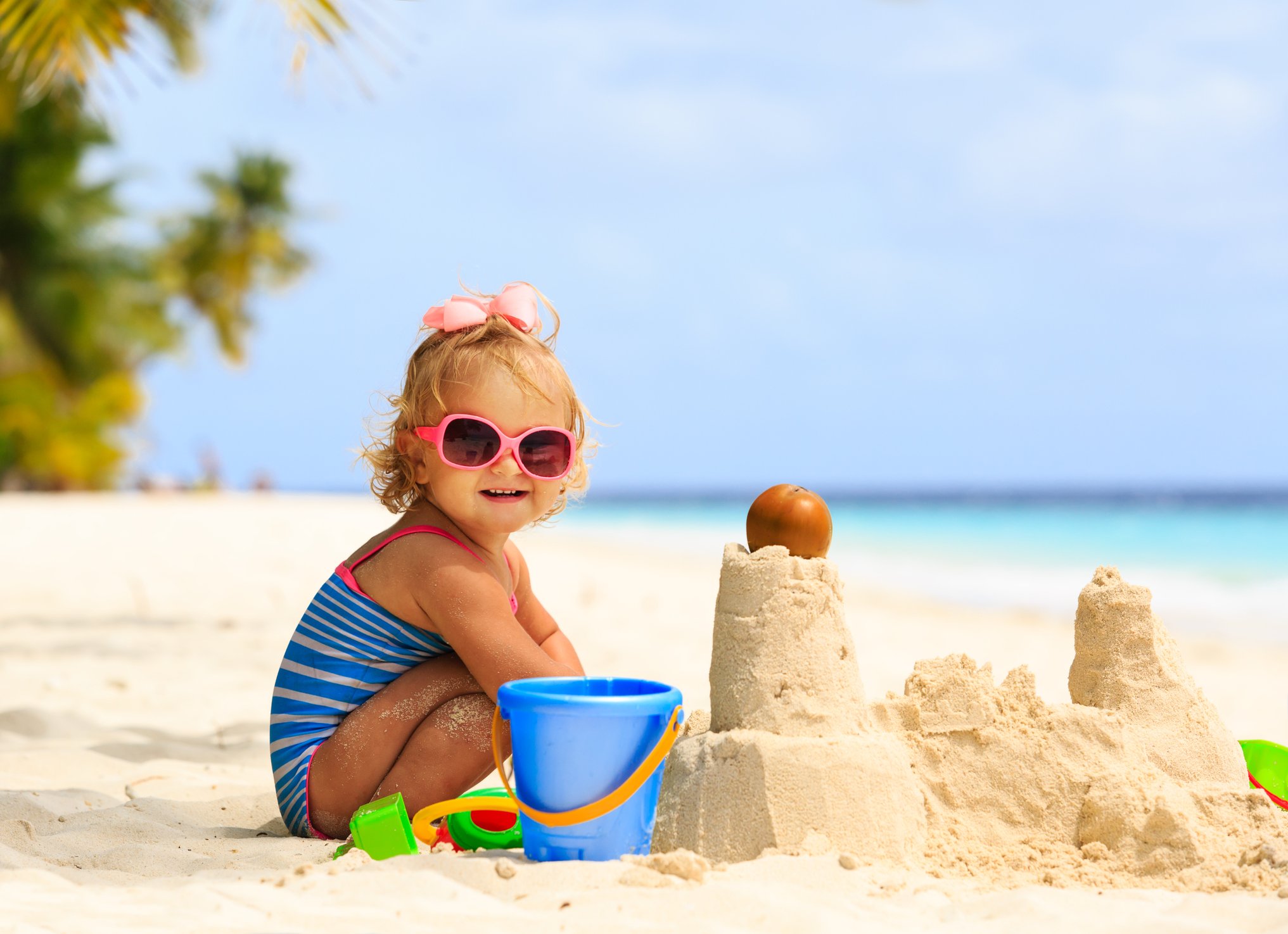 cute little girl playing with sand on beach