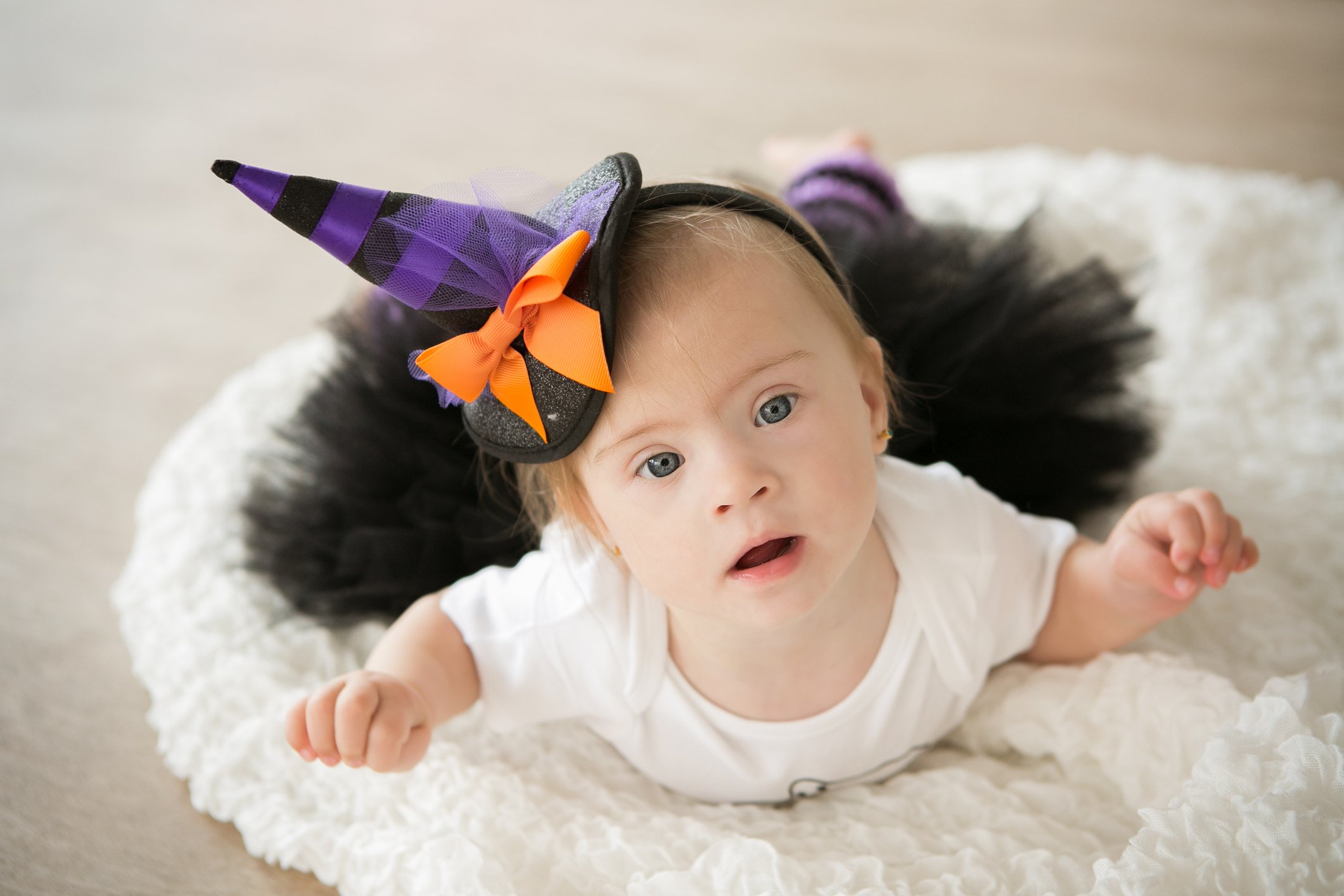 beautiful little girl with Down syndrome in a suit a little witch