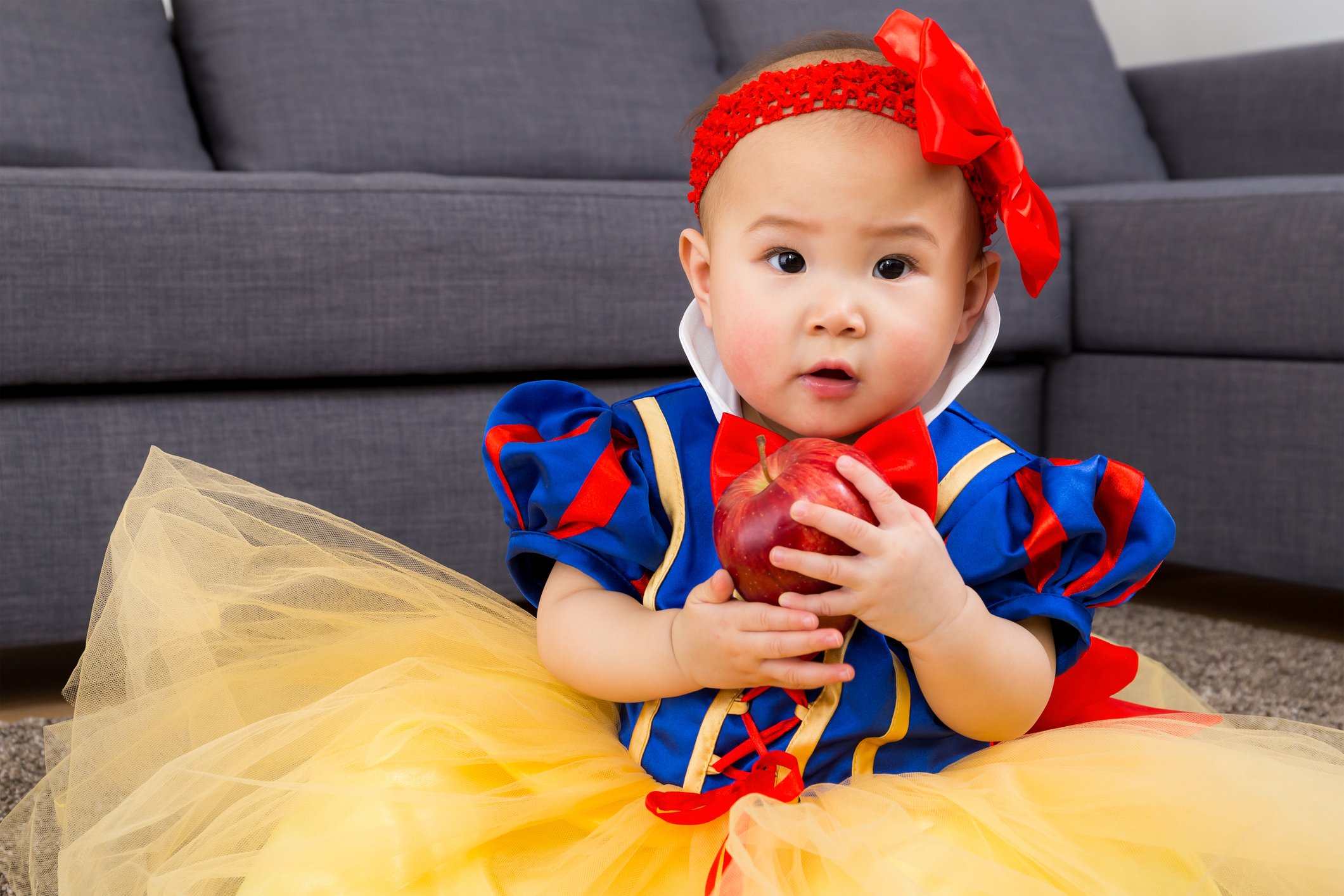 Baby girl holding an apple with party dressing