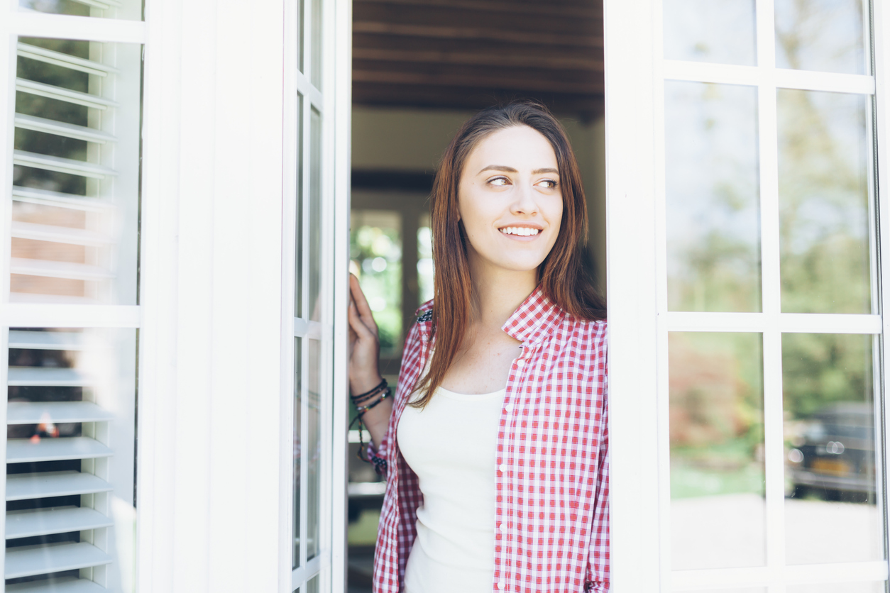 Young woman looking through the window