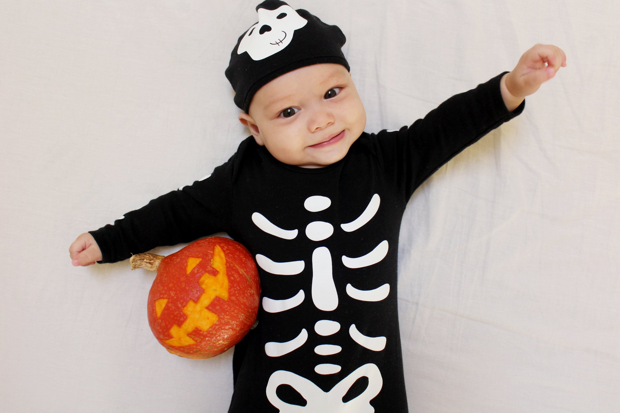 Cute baby boy wears skeleton Halloween costume