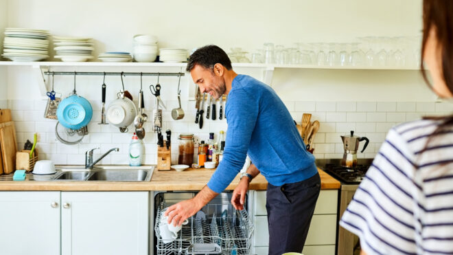 man unloading dishwasher