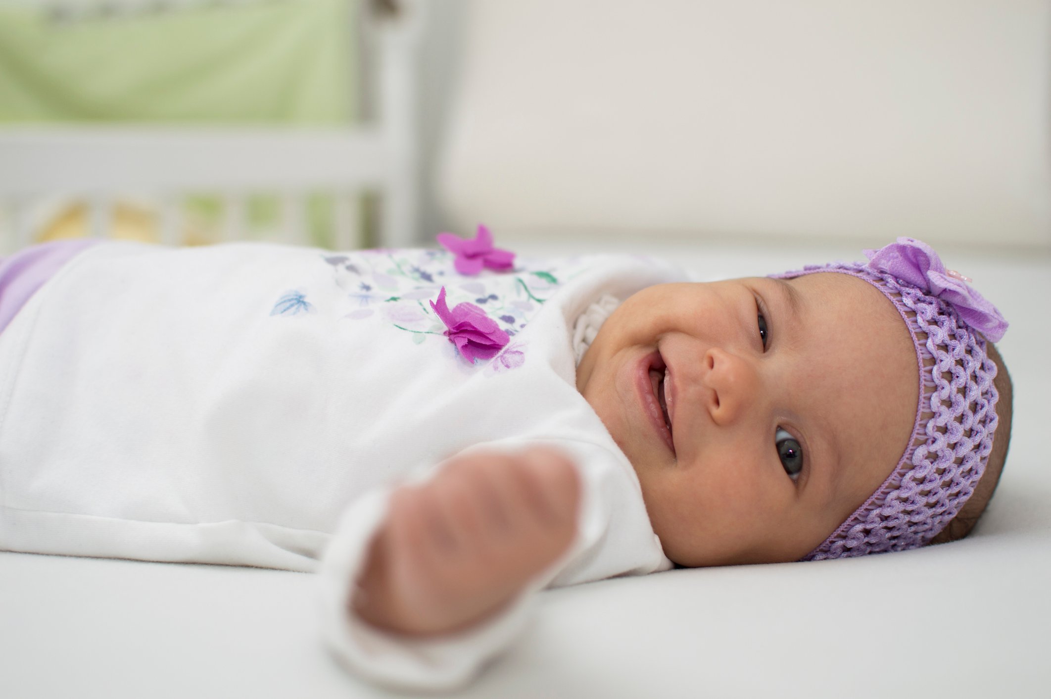 Happy newborn baby girl winking