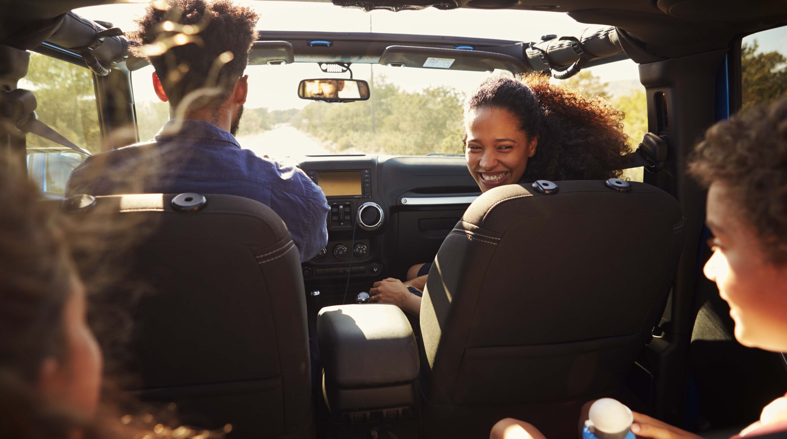 Excited family on a road trip in car, rear passenger
