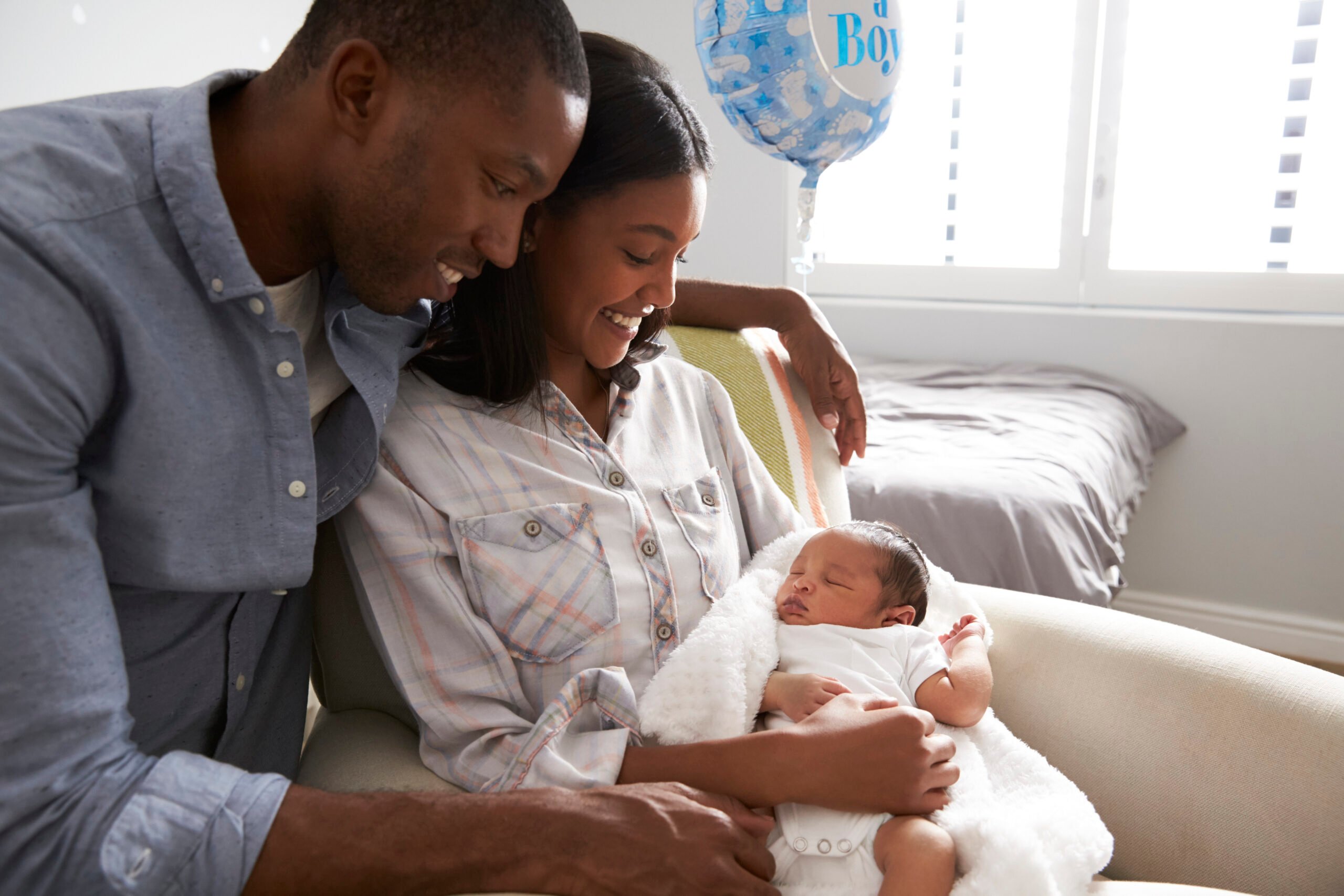 Black couple holding newborn baby - baby names Black history