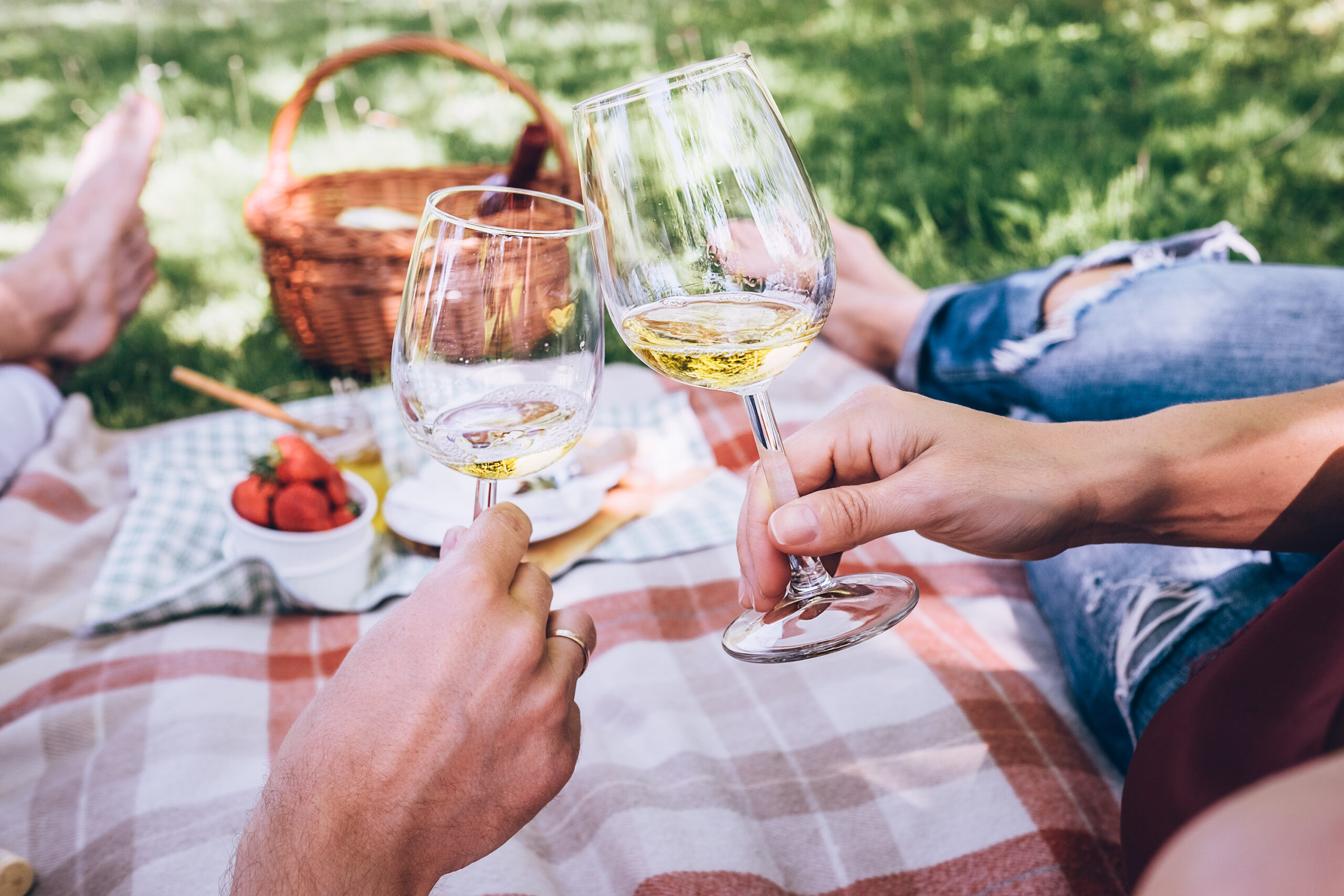 Couple in love drinks a white wine on summer picnic