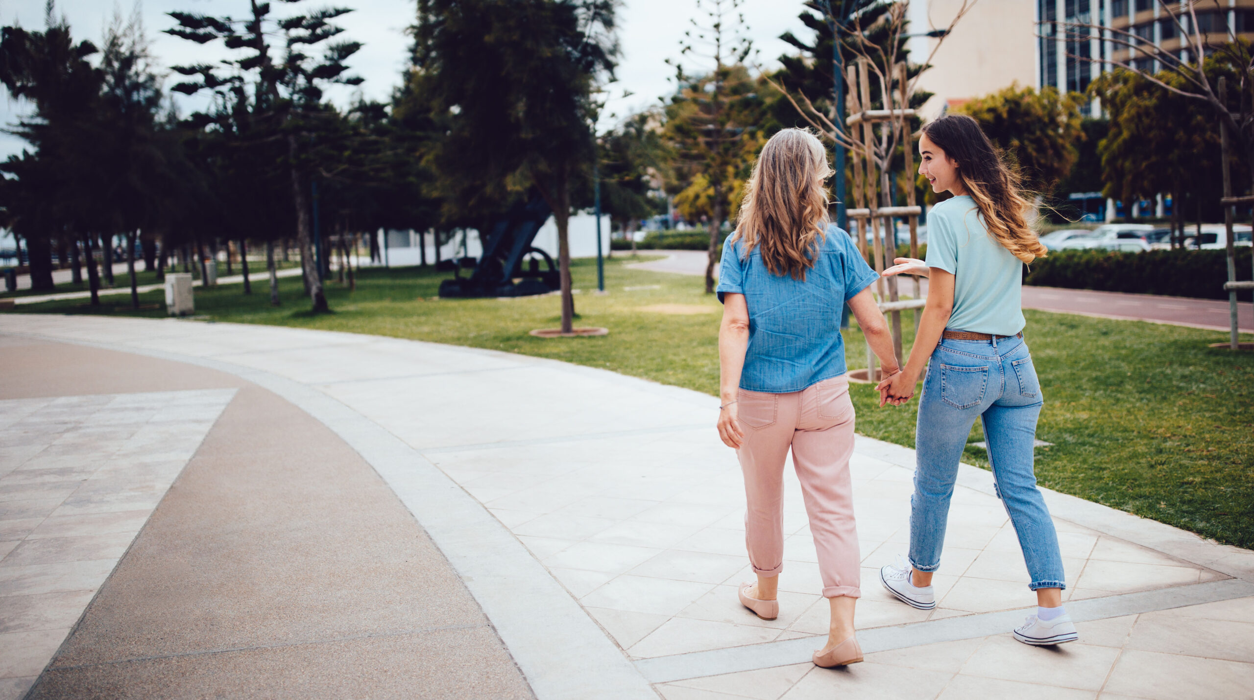 Active senior mother walking in the park with young daughter