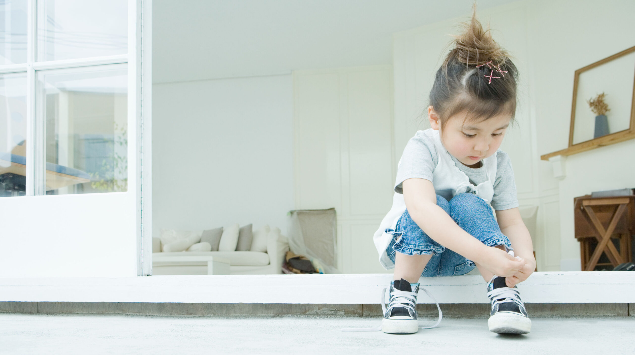 Girl learning to tie her shoelaces