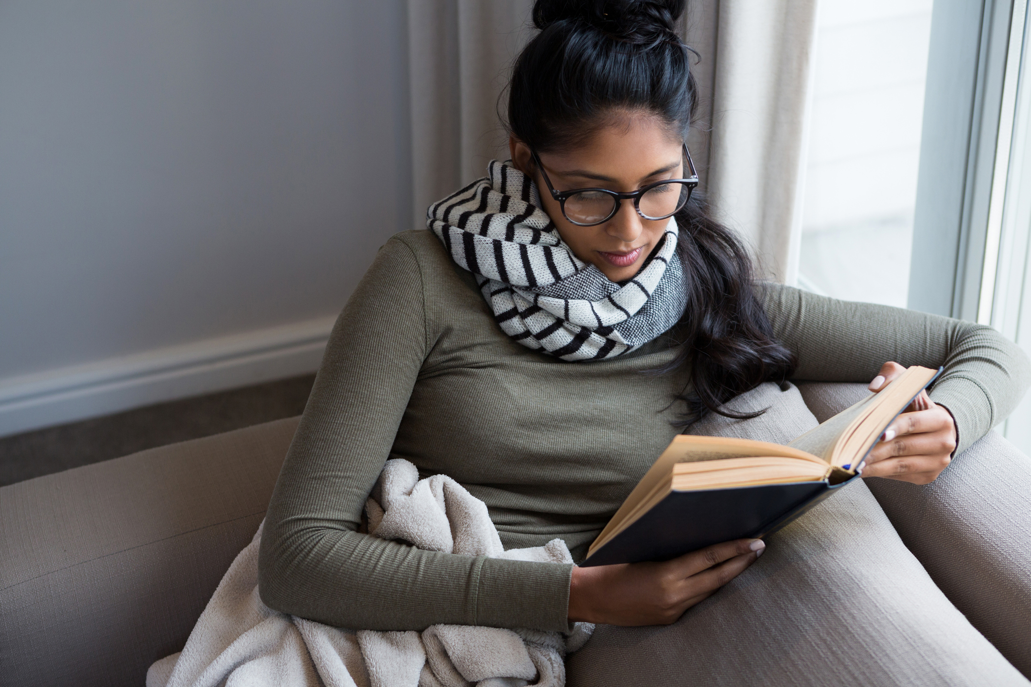 Woman reading book on sofa