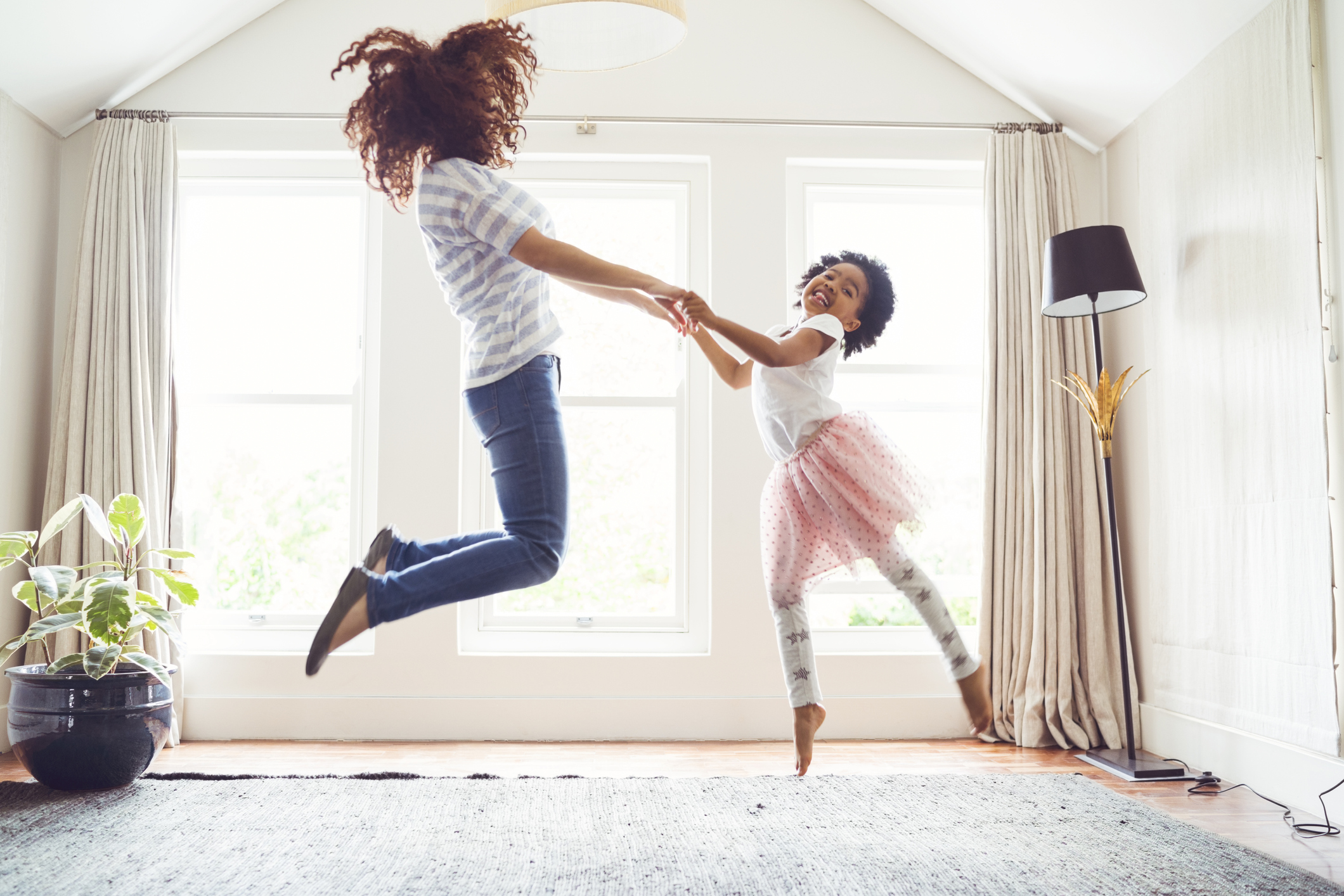 mom daughter jumping on bed