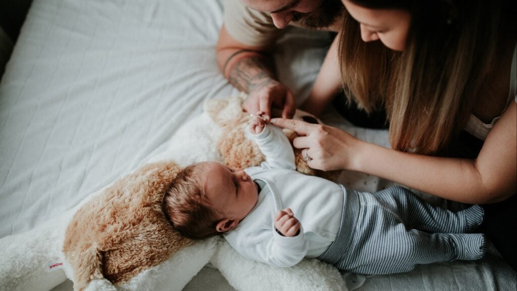 A couple playing with a newborn
