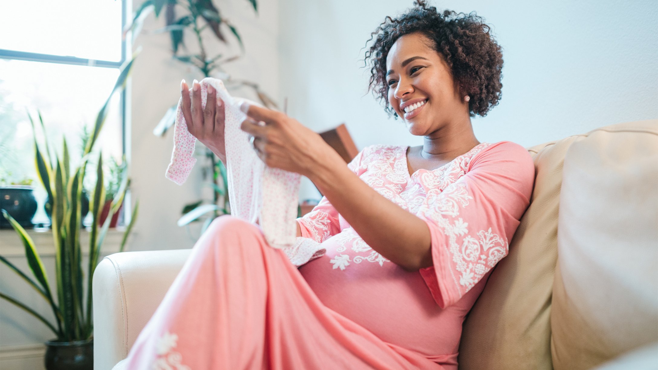 Pregnant Woman Receives Infant Clothing at Baby Shower