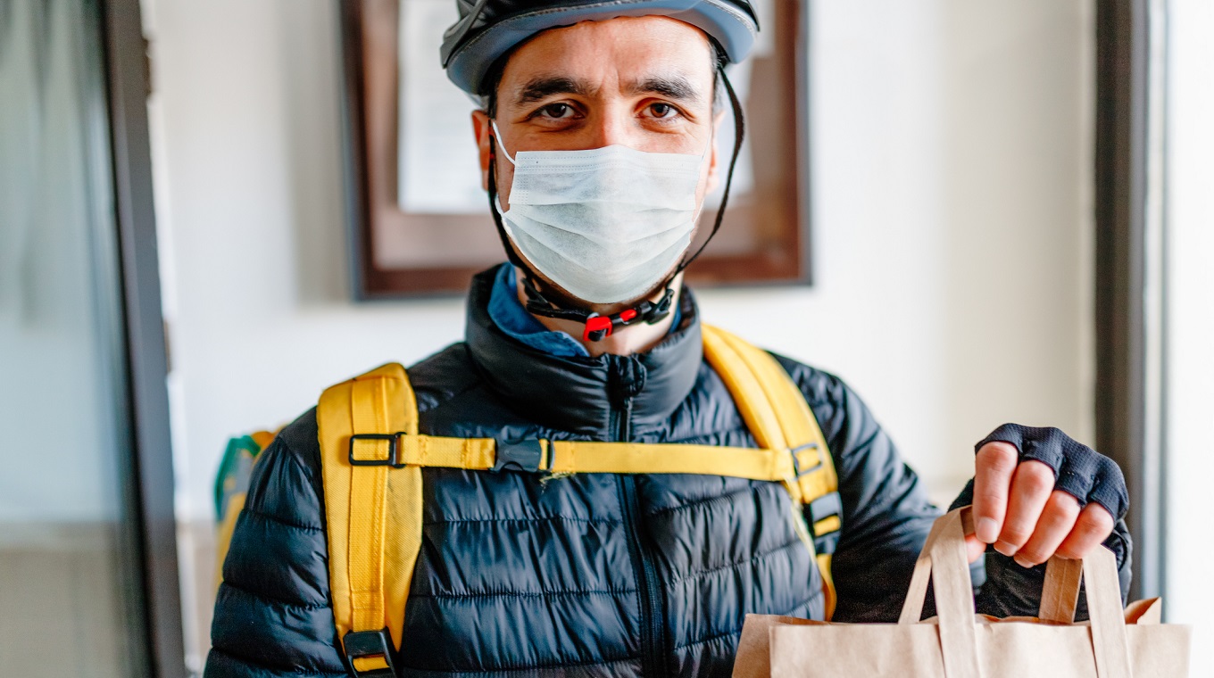Young man as a courier delivering food