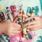 kids-hands-holding-crayons
