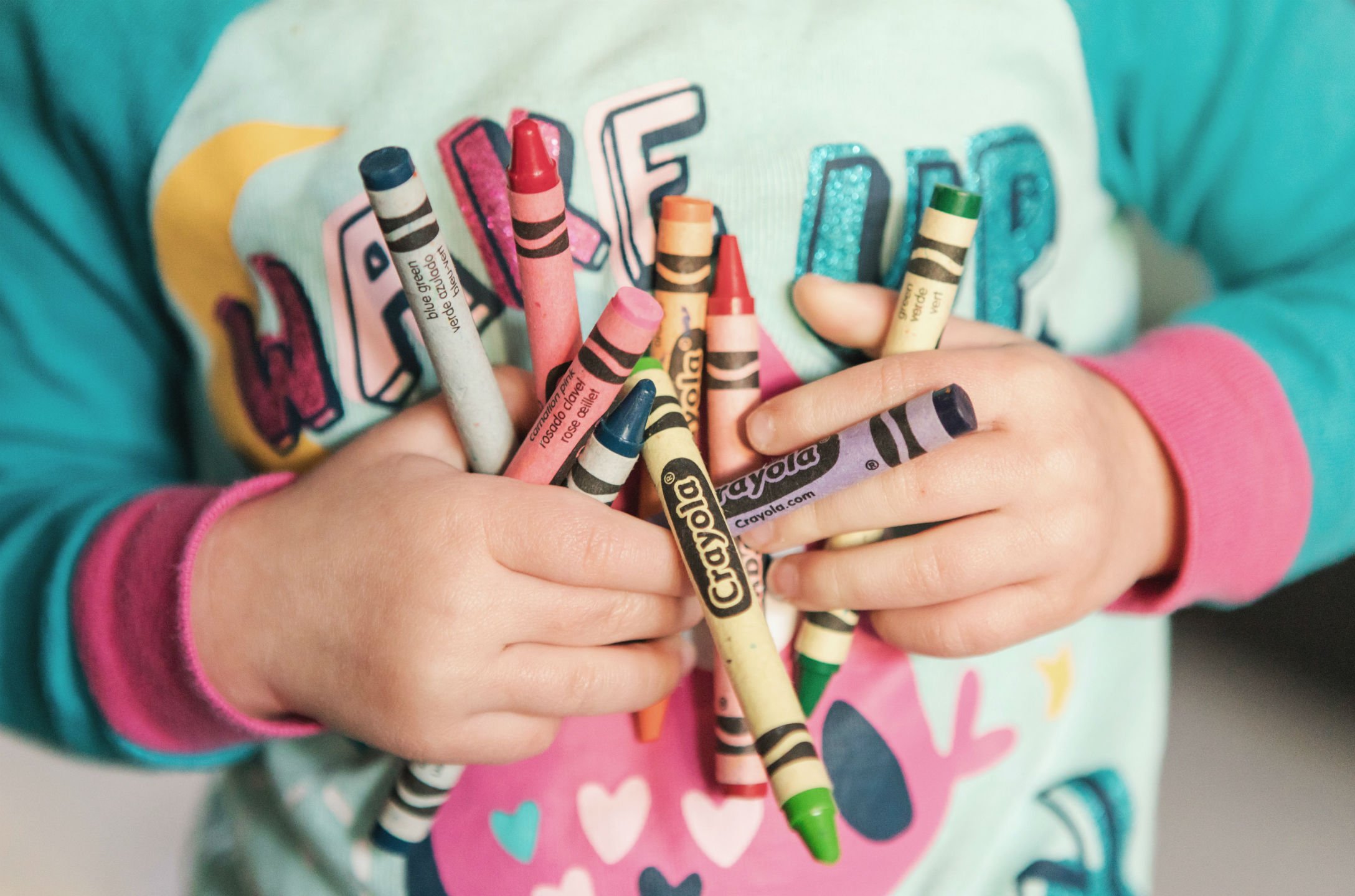 kids-hands-holding-crayons