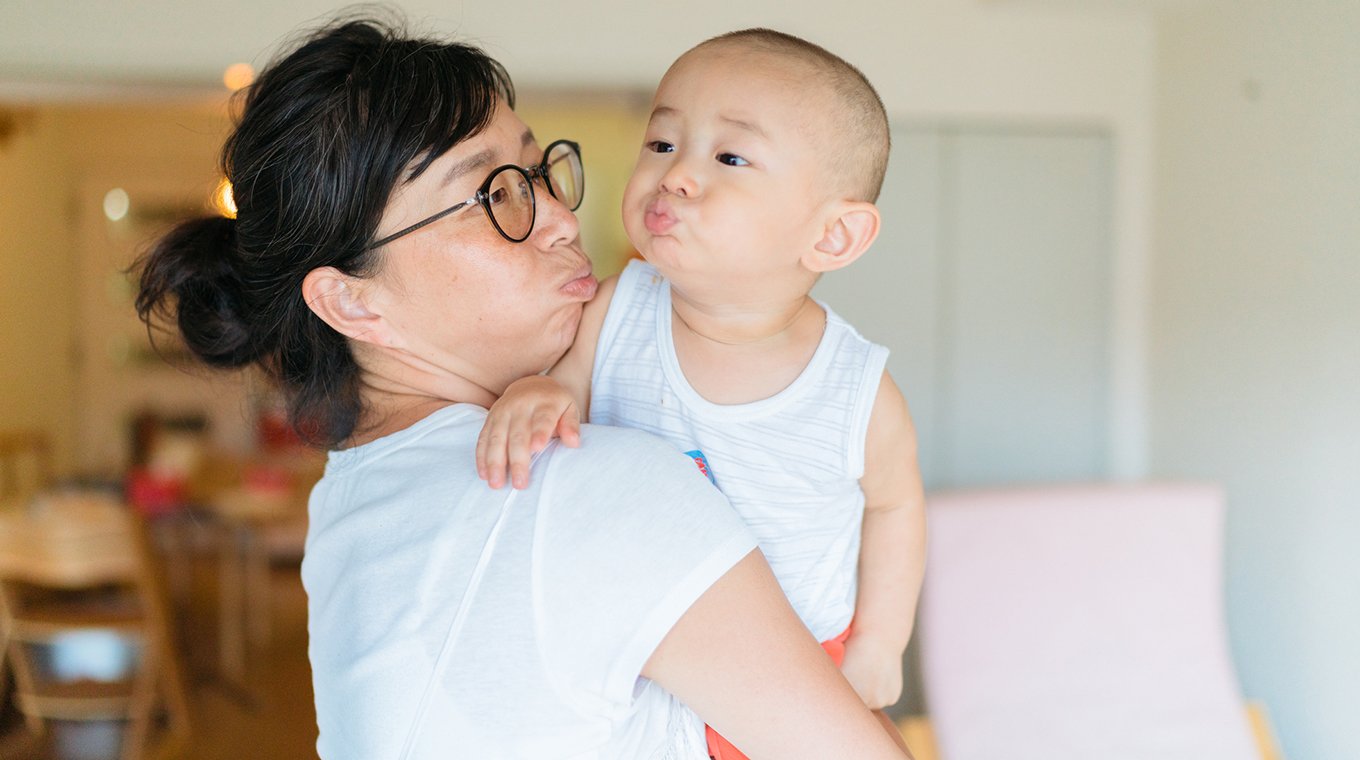 Mother and baby boy making funny face