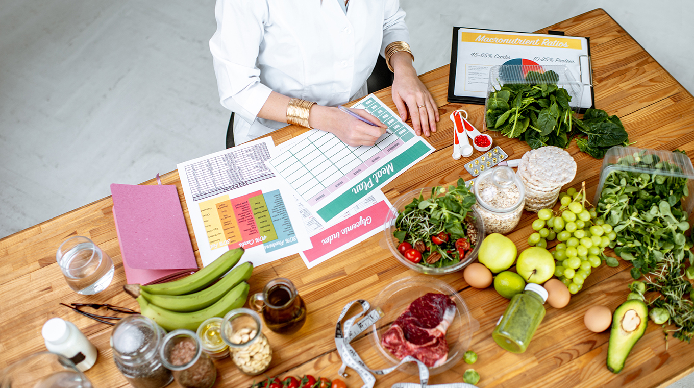 Writing a diet plan on the table full of healthy food