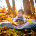 Baby girl in the park on sunny autumn day
