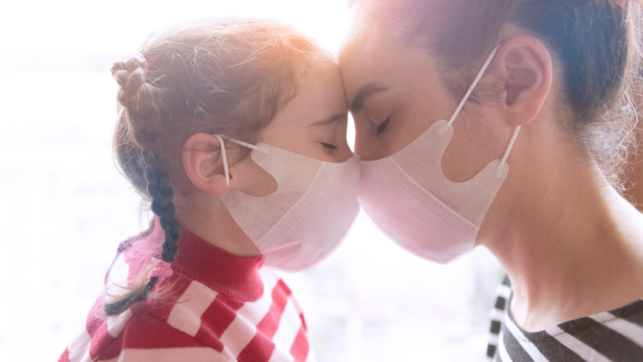 mother and little daughter wearing surgical mask