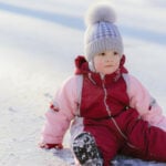 baby sitting in the snow