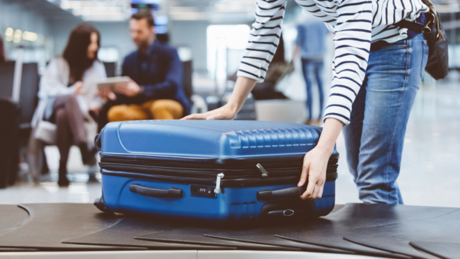woman picking up her bags at the airport